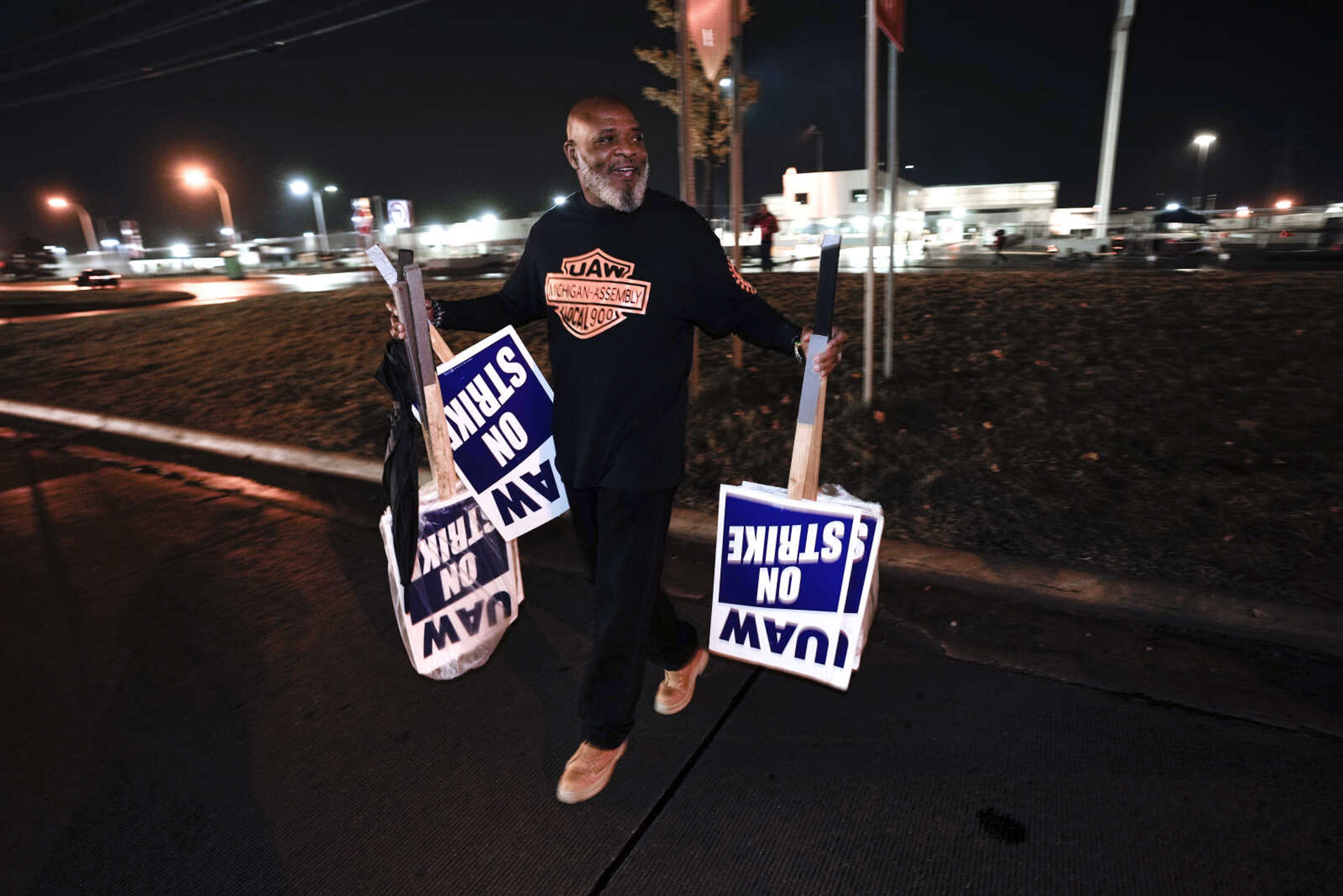 United Auto Workers member Marcel Edwards carries On Strike signs from the picket line to Local 900 headquarters Wednesday at the Ford Michigan Assembly Plant in Wayne, Michigan. The United Auto Workers union said Wednesday it has reached a tentative contract agreement with Ford that could be a breakthrough toward ending the nearly 6-week-old strikes against Detroit automakers.