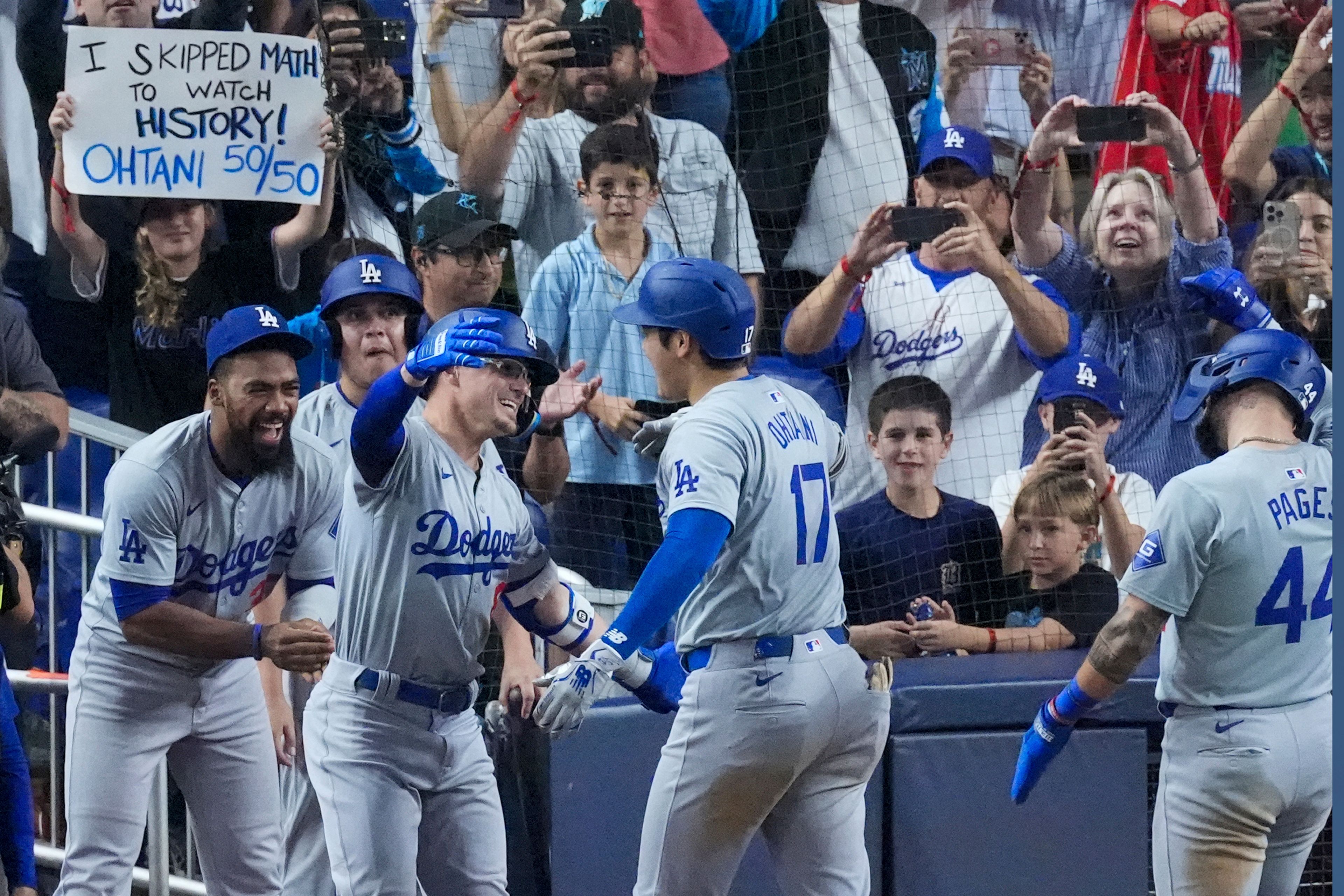 Los Angeles Dodgers' Shohei Ohtani (17) congratulated by teammates after he hit a home run scoring Andy Pages, during the seventh inning of a baseball game against the Miami Marlins, Thursday, Sept. 19, 2024, in Miami. (AP Photo/Wilfredo Lee)