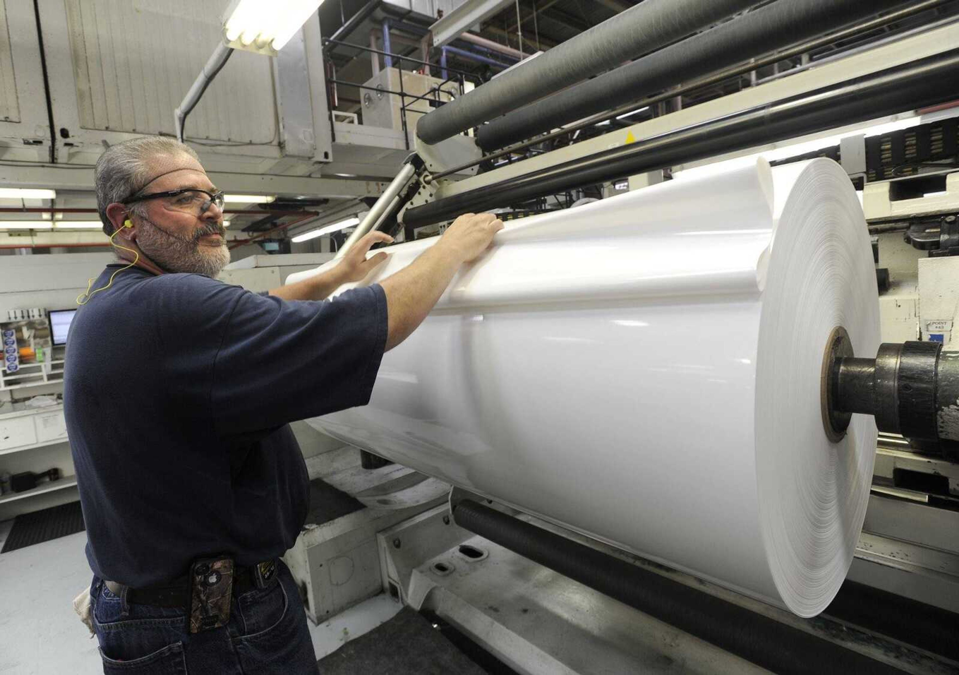 Press operator Ron Kemp changes a finished roll of coated label film Friday, July 20, 2012 at Nordenia USA. (Fred Lynch)