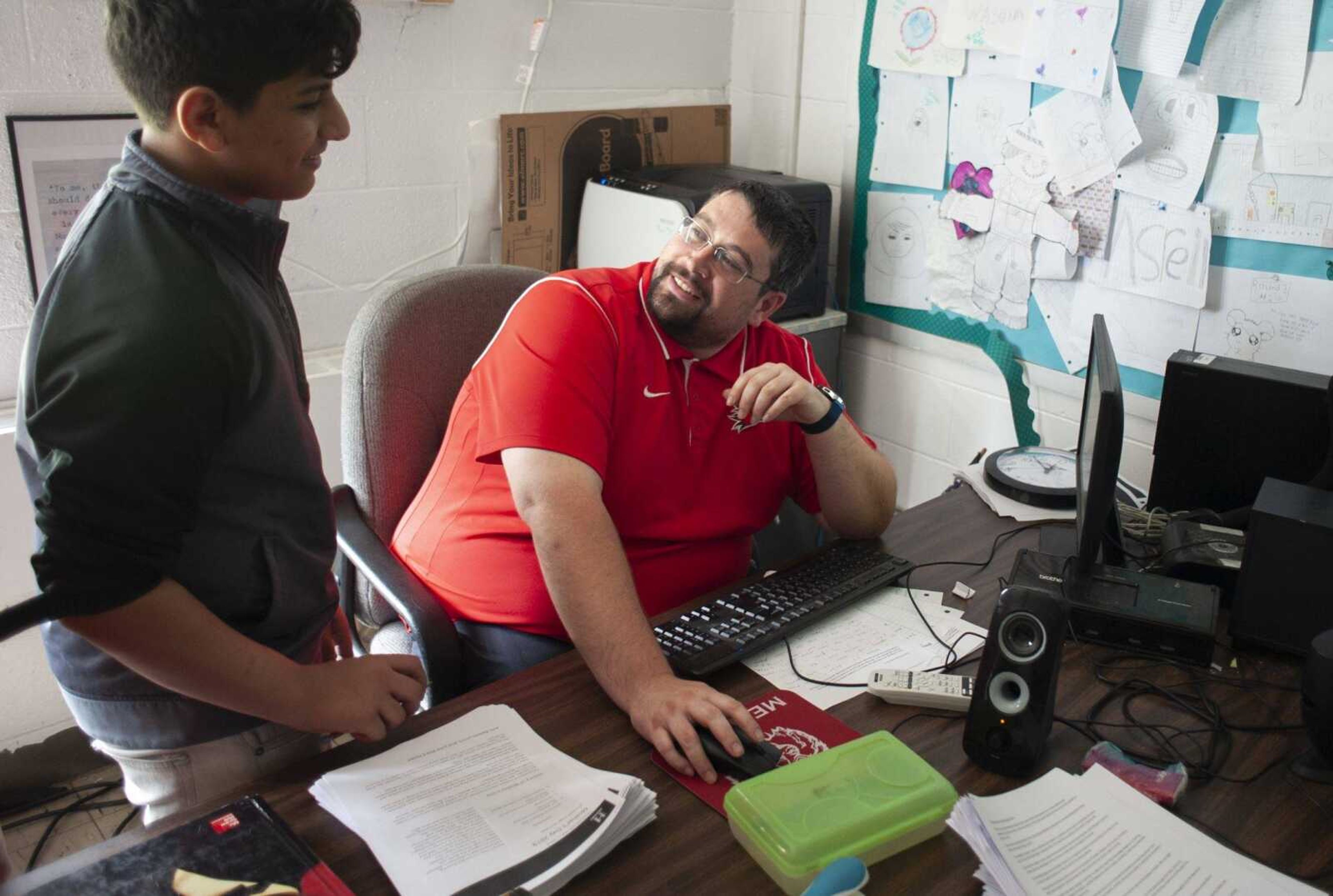 Alex Washam speaks with Meridian sixth grader Mohamed Albanna on May 7 at Meridian High School in Mounds. Originally working at the school as a custodian, Washam is now is a "full-time substitute teacher." He has a master's degree and is working on his teaching certification. "This is my school. This is where I want to be. This is home," he said. "There's a teacher shortage and I wanted to help my school." Washam is a lifelong resident of Mounds and a 2006 graduate of Meridian High School.