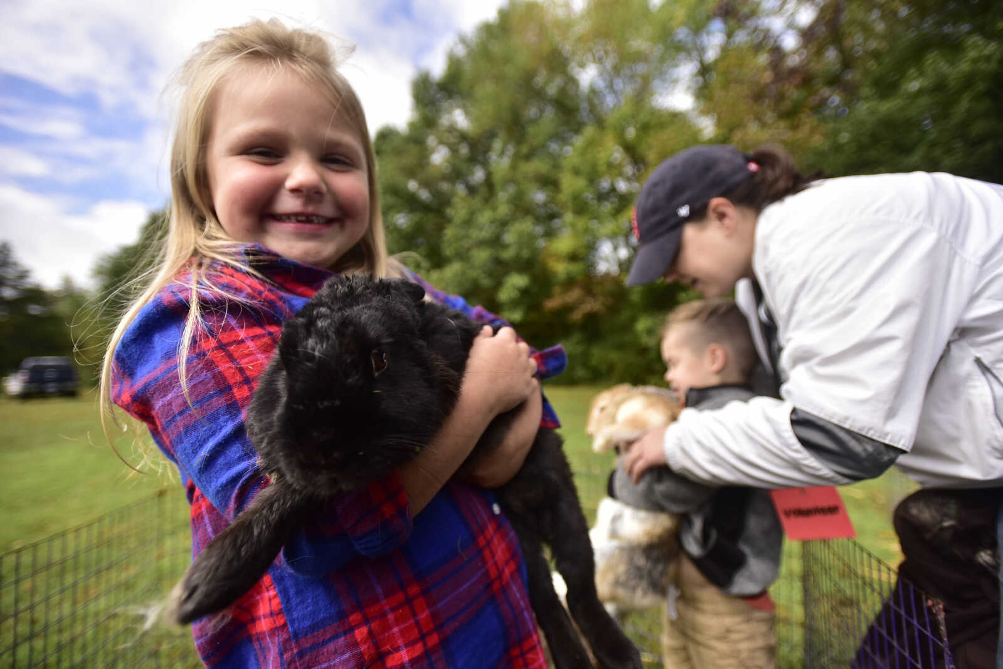 Gracie Hann, 6, holds a bunny while visiting the petting zoo at the inaugural Fishing Rodeo held Oct. 15, 2017 at Elks Lake in Cape Girardeau.