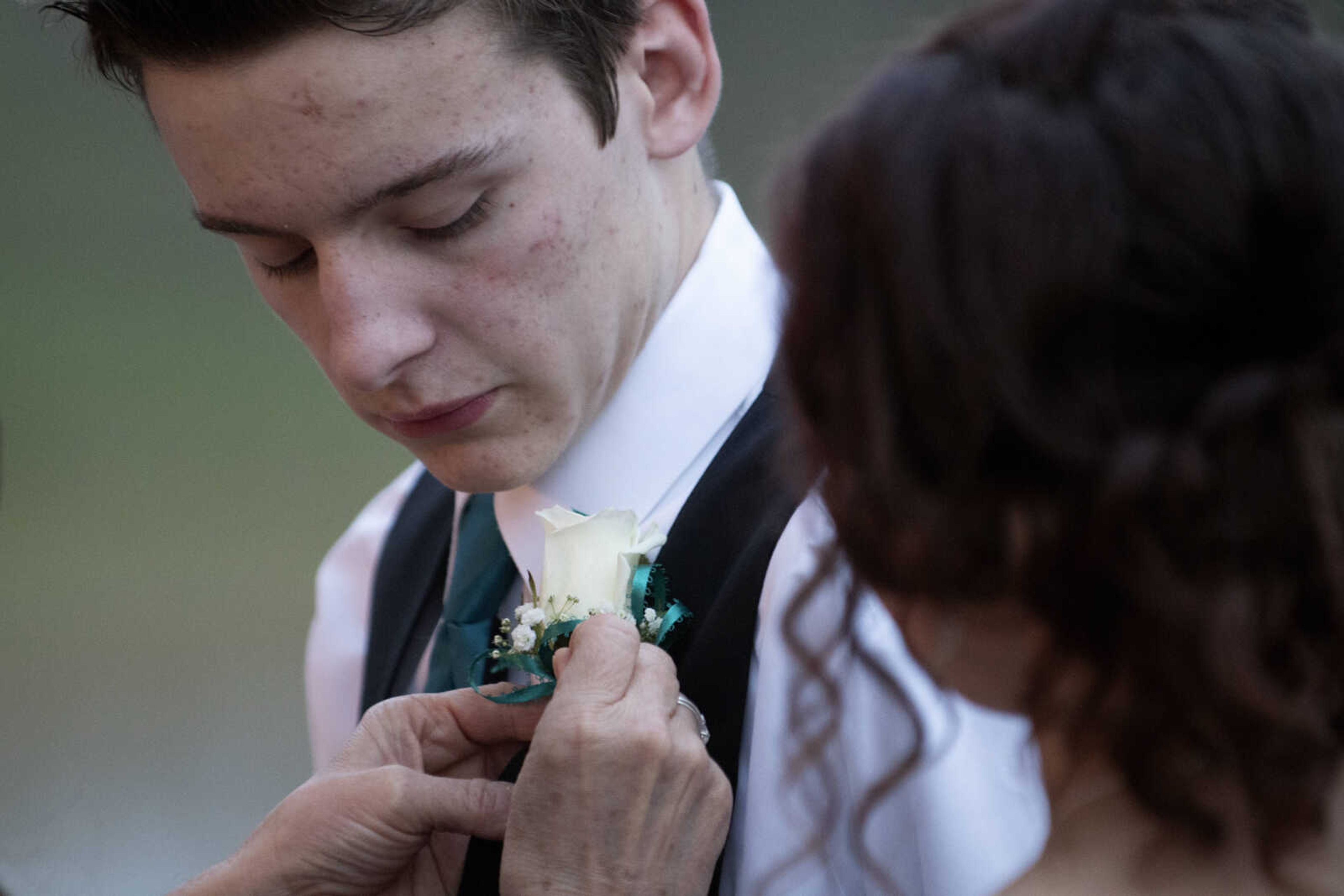 Scott City junior Dalton Ledure has his boutonniere attached near Jackson junior Britney Koenig during Scott City's prom Saturday, April 6, 2019, at Deerfield Lodge in Cape Girardeau.