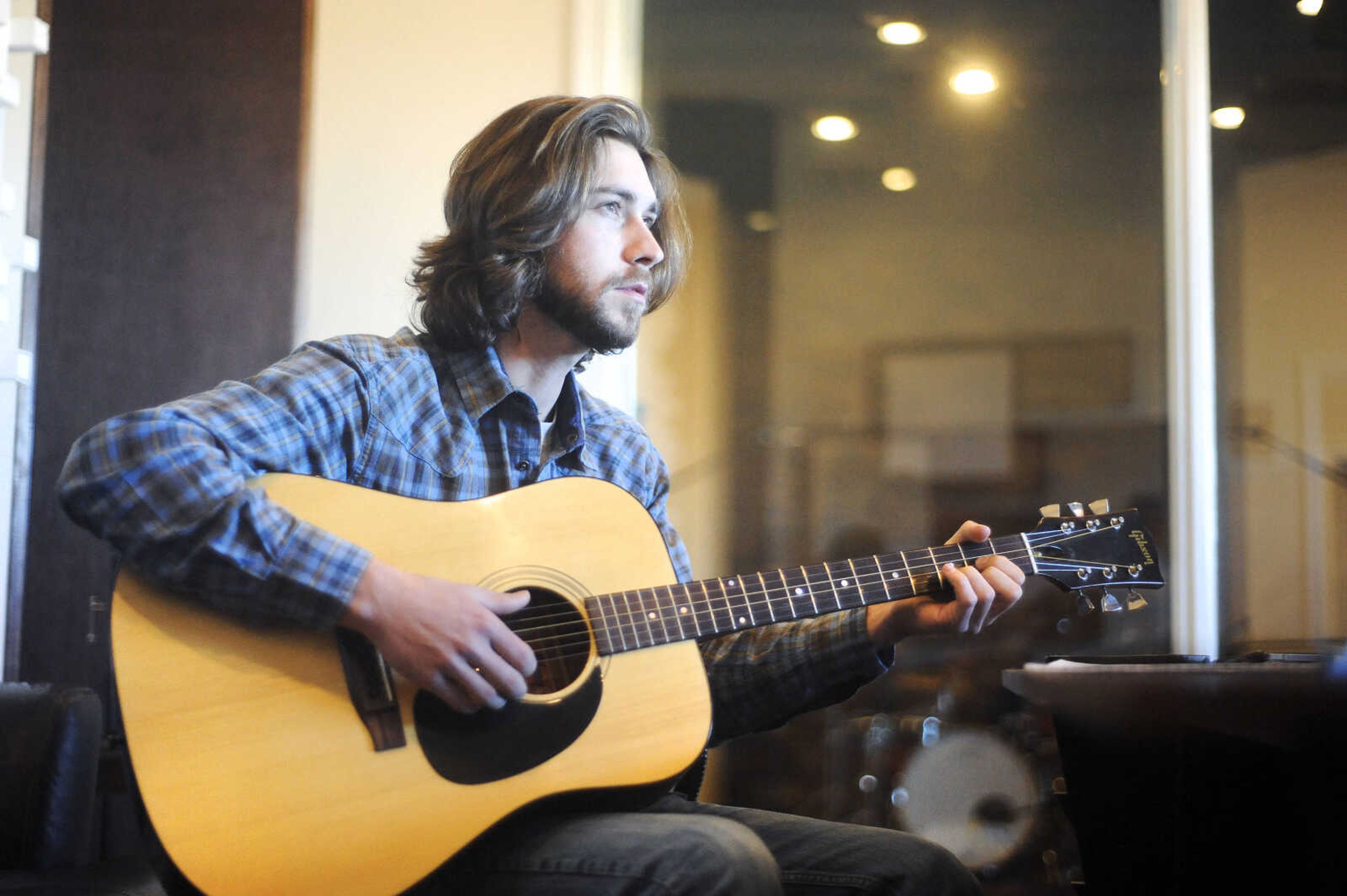 LAURA SIMON ~ lsimon@semissourian.com

Evan Webb, of Evan Webb and the Rural Route Ramblers, strums a tune on his guitar at Blue Creek Production in Patton, Missouri, Sunday, Jan. 10, 2016. Webb and bandmate Adam Hellman were putting the finishing touches on the band's new album, which includes the song, 'Dry up or Drown' that went viral during the recent flooding in the area.