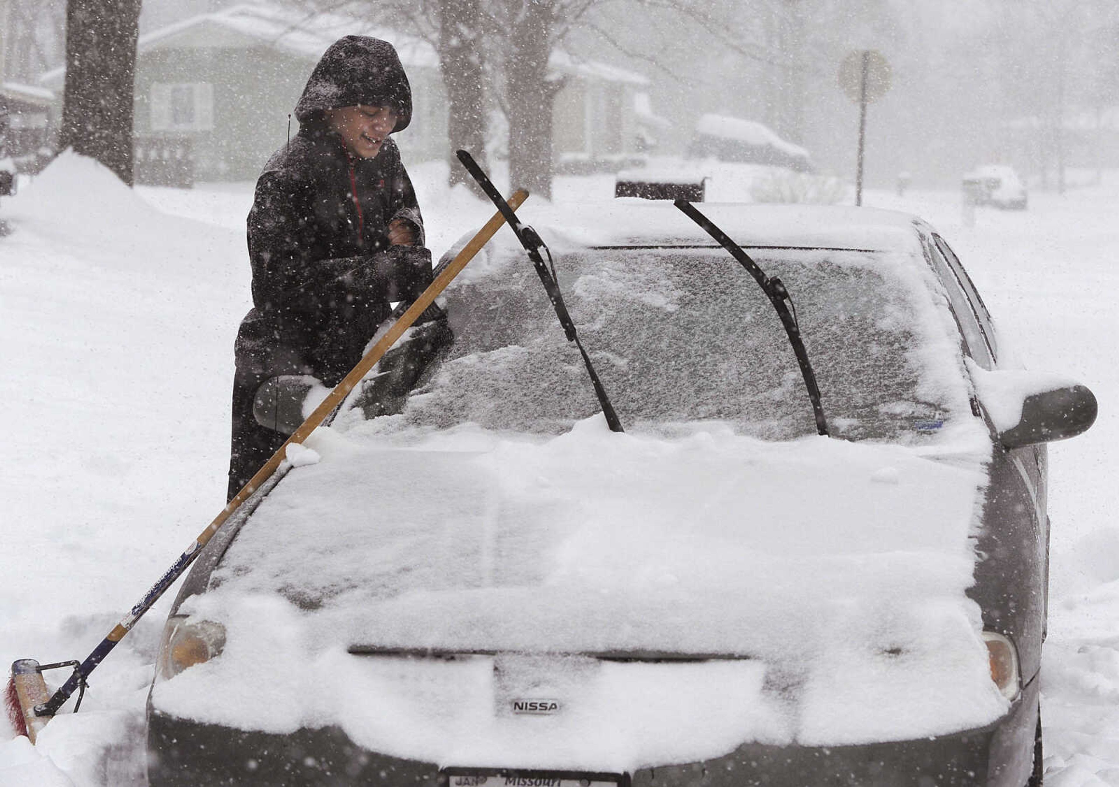 FRED LYNCH ~ flynch@semissourian.com
Isaiah Evans scrapes ice after clearing snow from his car before  going to work Monday morning, Feb. 16, 2015 in Cape Girardeau.