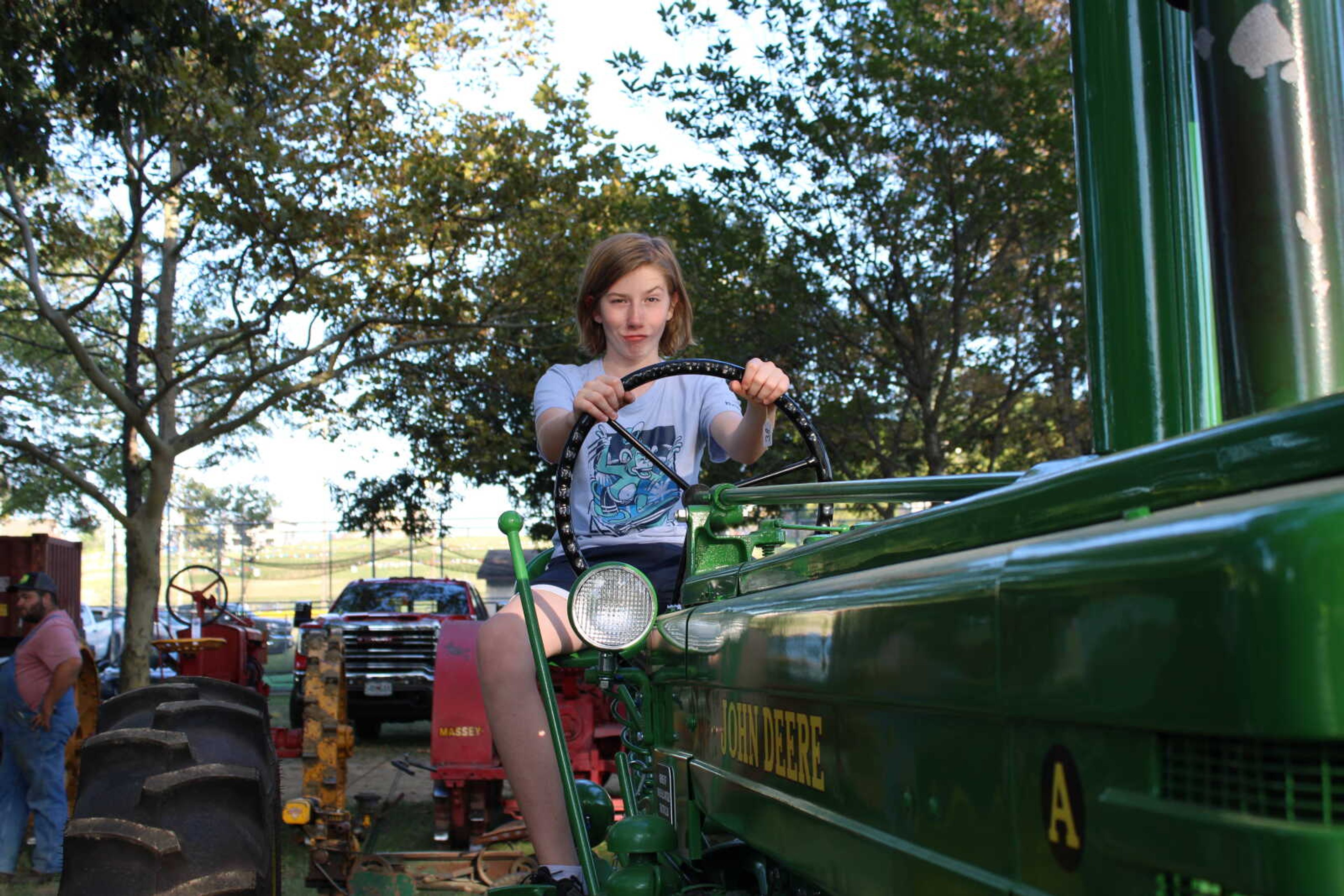 Conner Patterson pretends to drive a John Deere tractor.