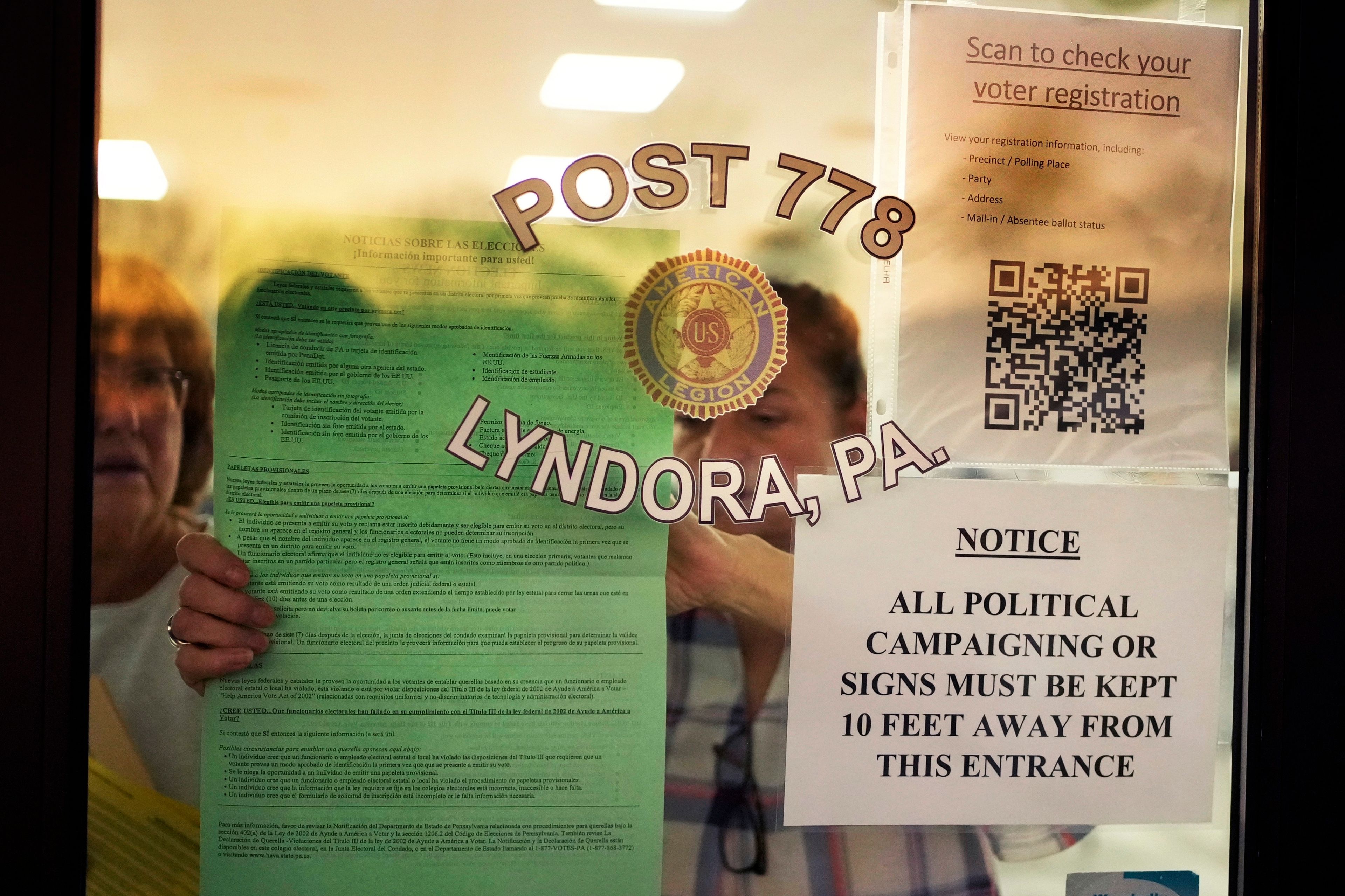 Officials post notices before opening the doors to voters at American Legion Post 778 in Butler Township, Pa., on Election Day, Tuesday, Nov. 5, 2024. (AP Photo/Robert F. Bukaty)