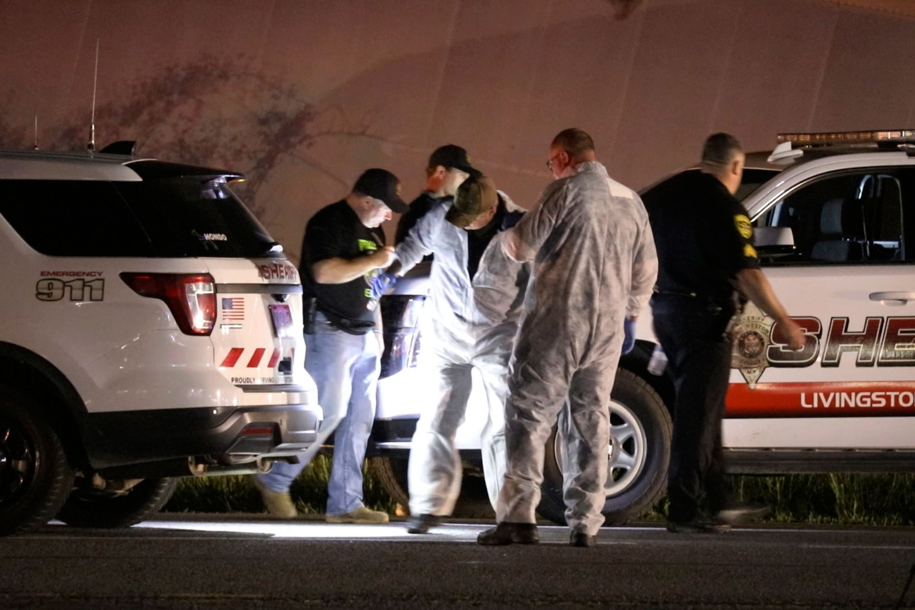 Livingston County Sheriff's deputies check their vehicles for bullet holes in Geneseo, N.Y., early Thursday, May 28, 2020, after a chase and shootout with Joshua Blessed, the driver of a tractor trailer. The incident started in LeRoy, N.Y., when police stopped the tractor trailer for speeding. Blessed took off and drove into Livingston County, leading law enforcement on a chase. (Tina MacIntyre-Yee/Democrat & Chronicle via AP, File)