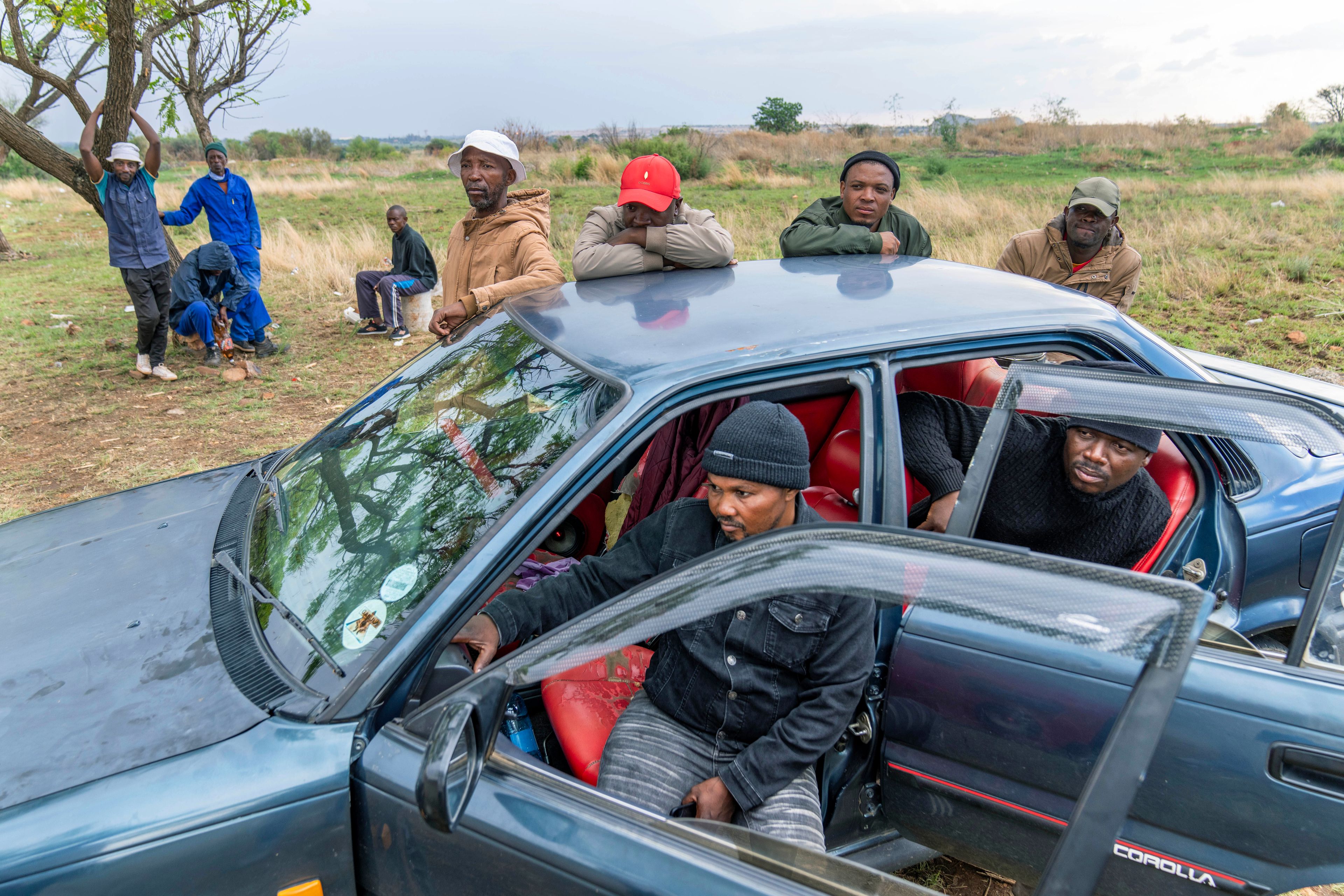 Relatives of miners and community members wait at a mine shaft where illegal miners are trapped in a disused mine in Stilfontein, South Africa, Thursday, Nov. 14, 2024. (AP Photo/Jerome Delay)