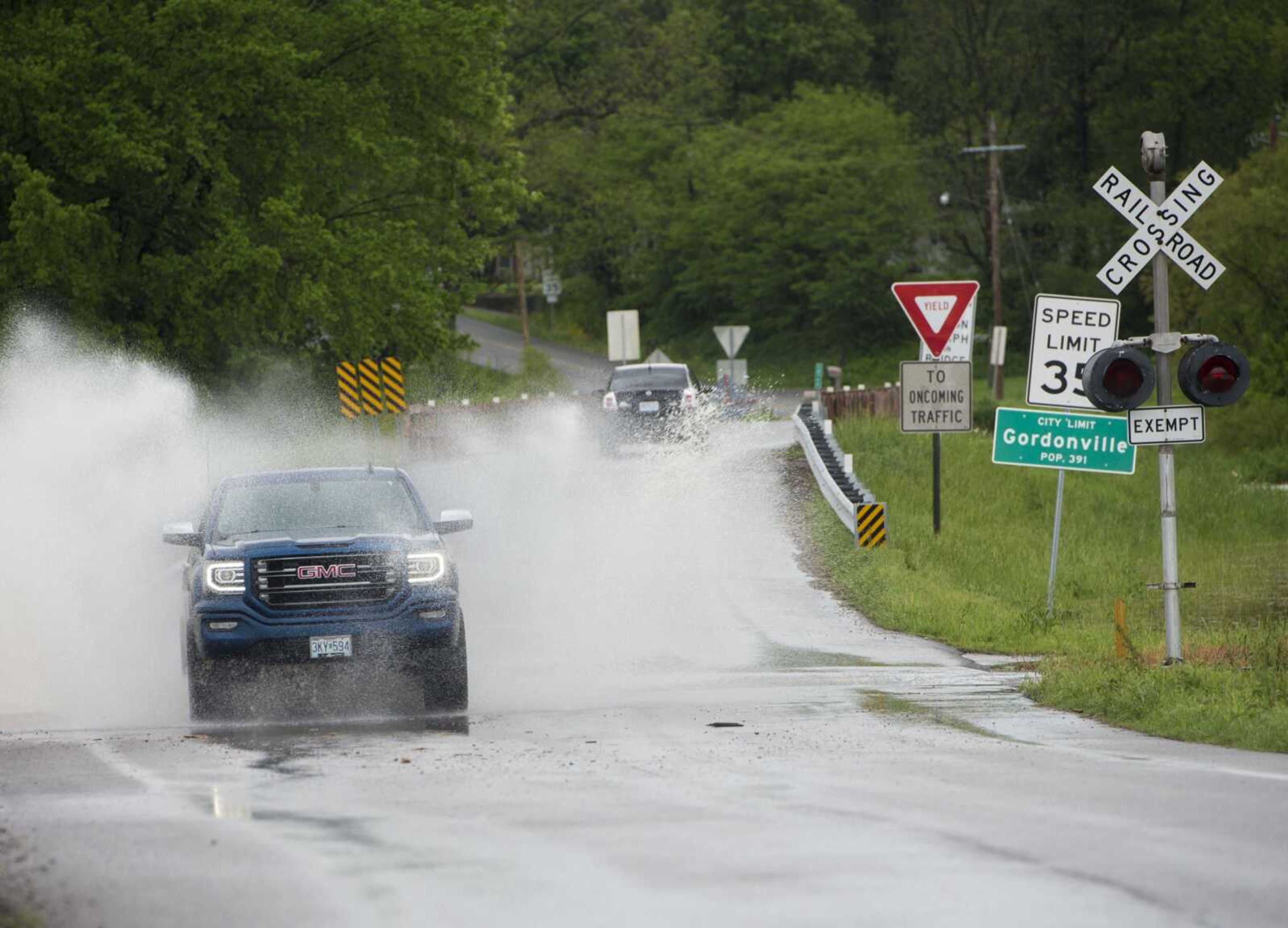 Drivers splash through floodwaters covering Route Z outside of Gordonville on Sunday.