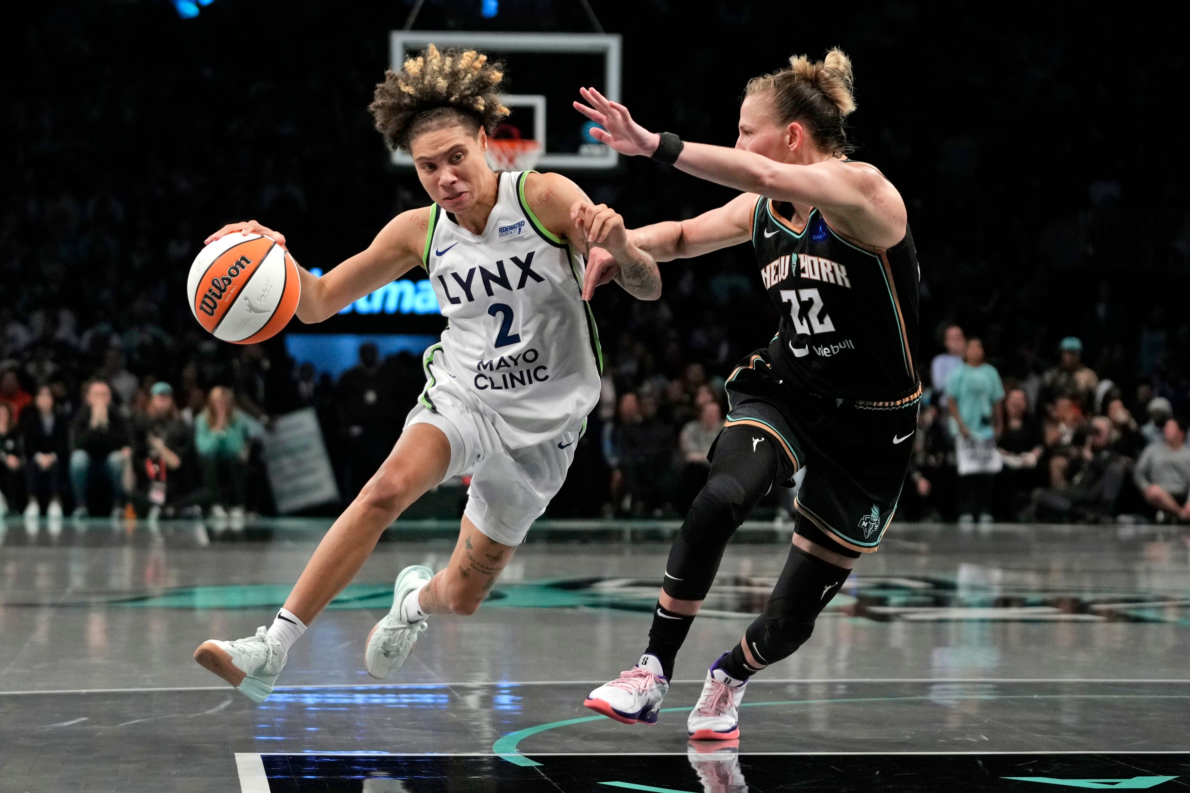 Minnesota Lynx's Natisha Hiedeman, left, dribbles against New York Liberty's Courtney Vandersloot, right, during the second half in Game 1 of a WNBA basketball final playoff series, Thursday, Oct. 10, 2024, in New York. (AP Photo/Pamela Smith)