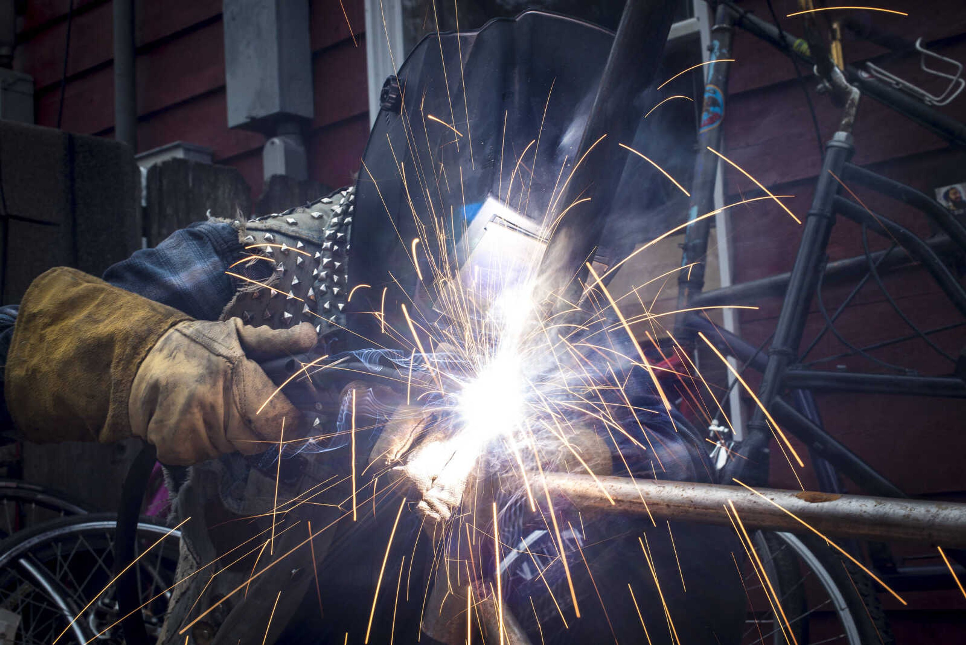 Sparks shoot off while Parker Bond welds together his tall bike Thursday, Dec. 21, 2017 in Cape Girardeau. When the weather is warmer Bond and his friends play Bike Polo at Arena Park, he said he would like to use his tall bike eventually during the game.