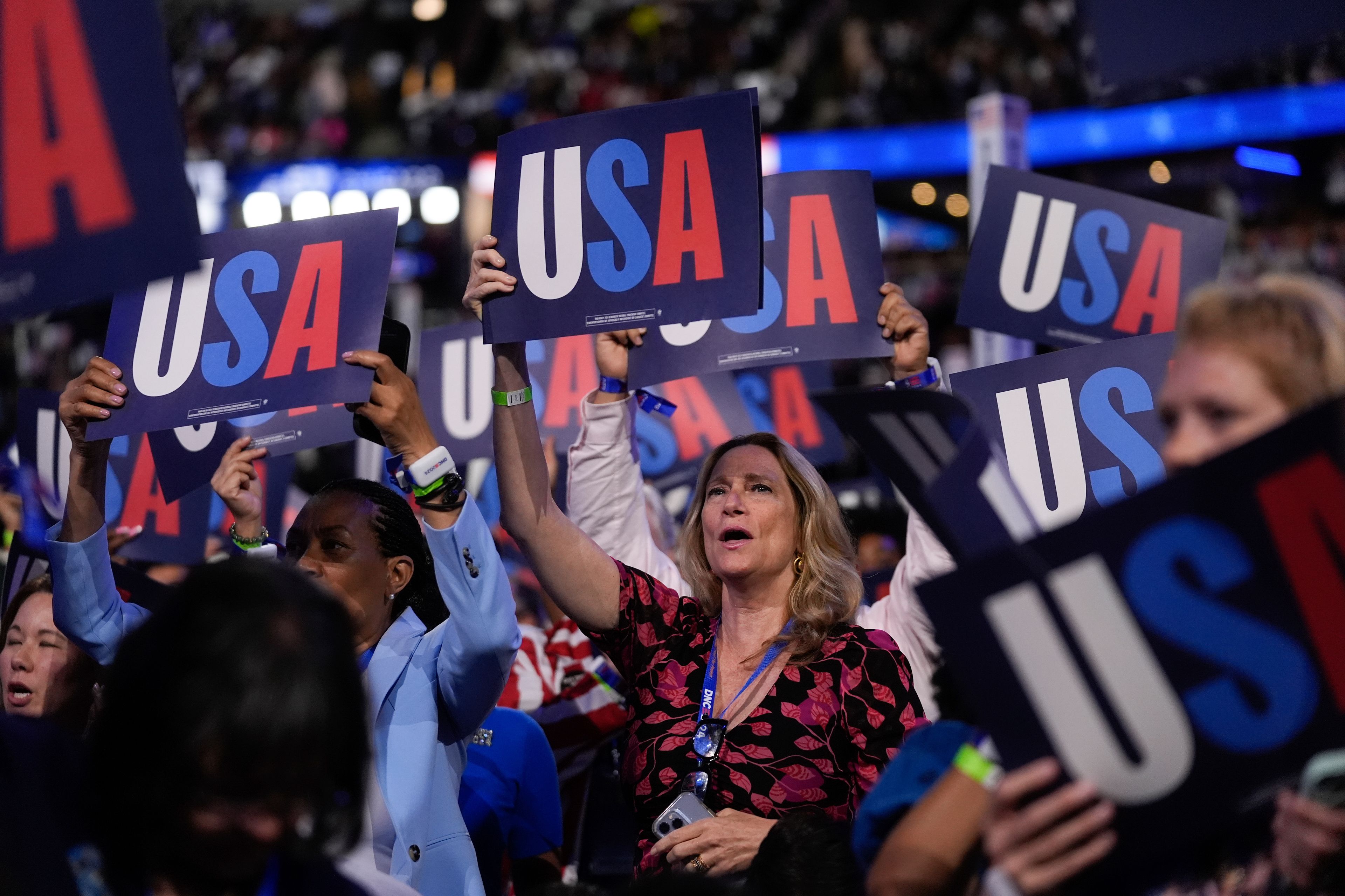 Delegates hold signs during the Democratic National Convention Tuesday, Aug. 20, 2024, in Chicago. (AP Photo/Erin Hooley)