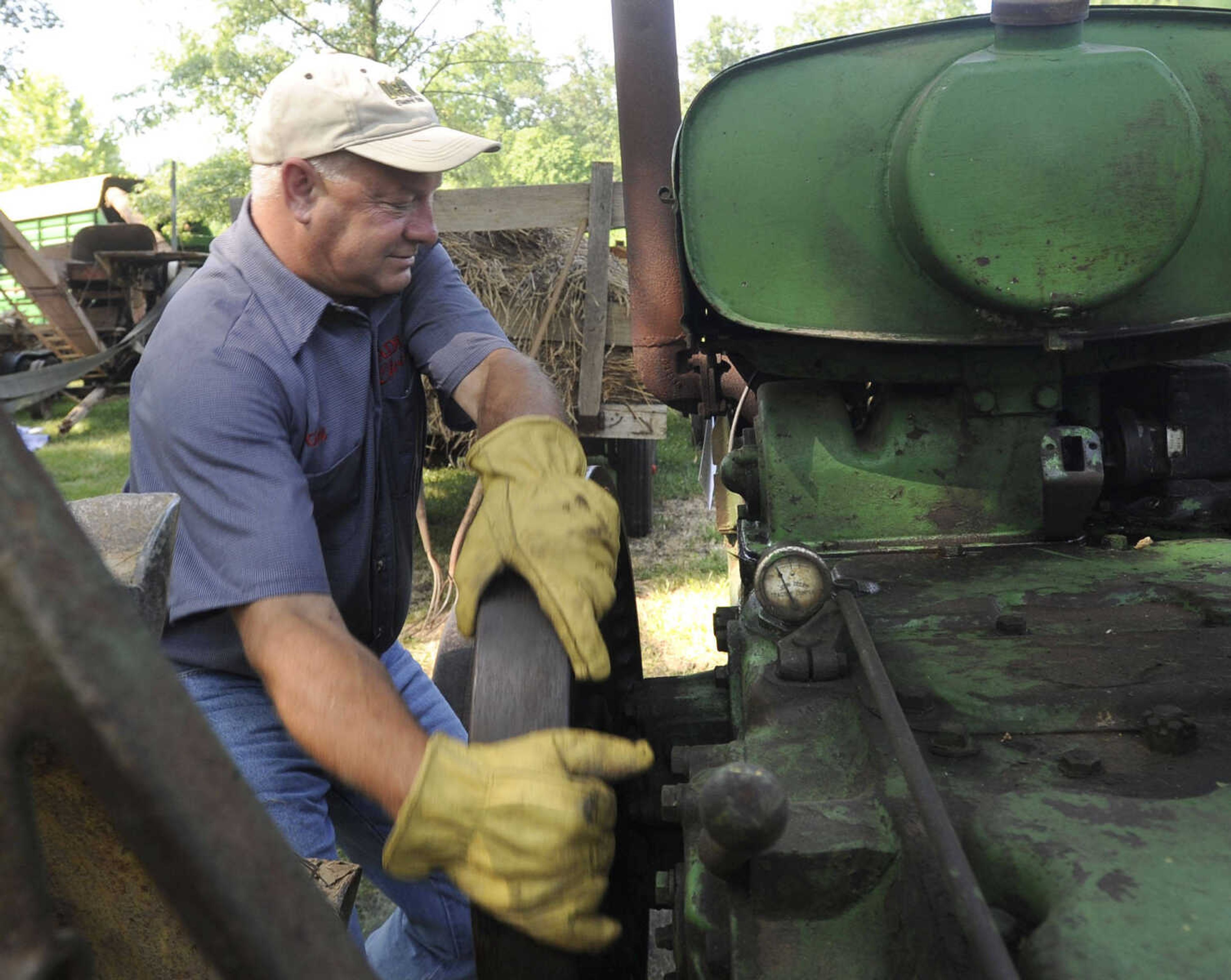 Greg Hadler starts up an engine to power a thresher Saturday at Old Timers' Day in Perryville, Mo.