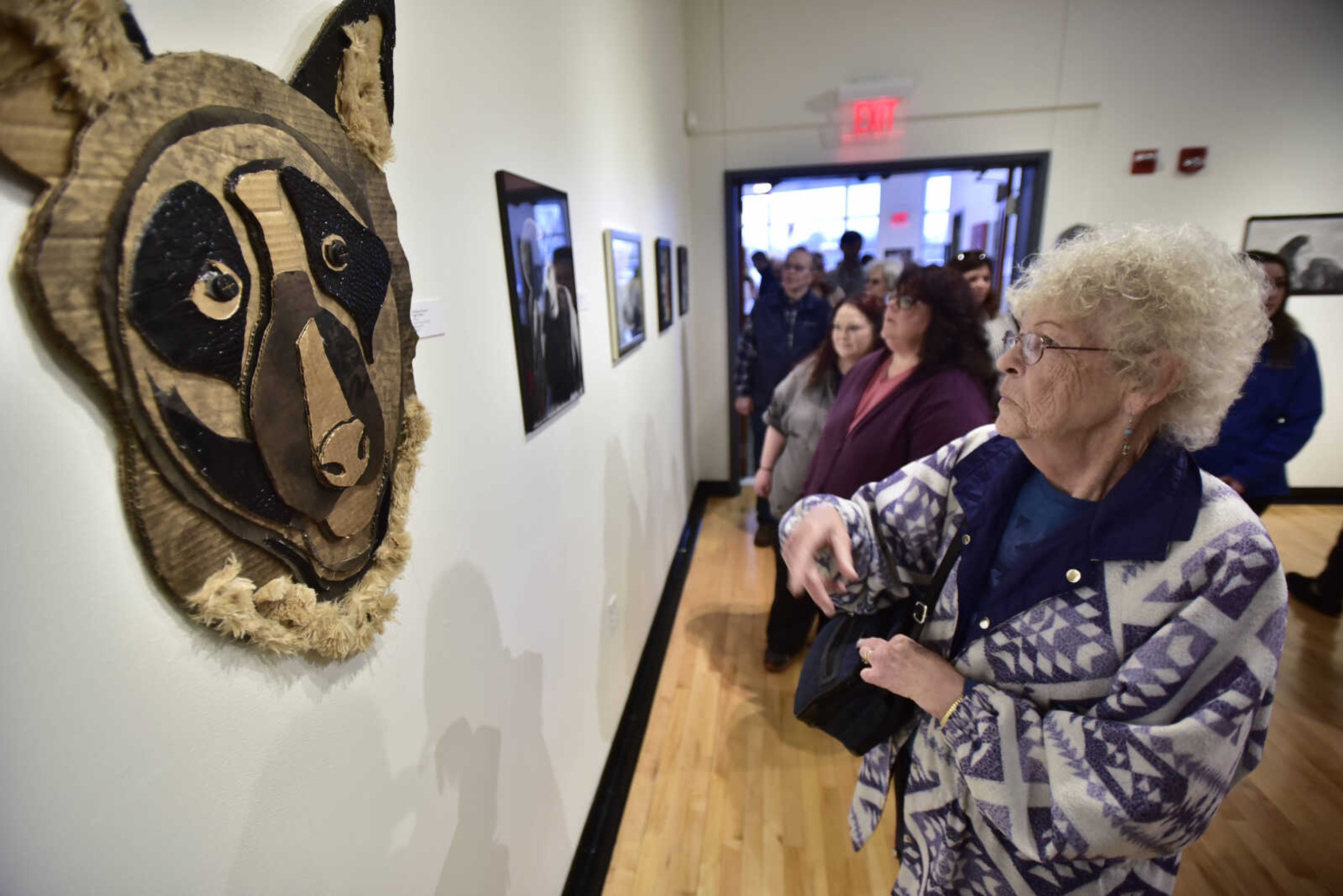 Ruth Stephens, right, discusses "Night Watch", a mixed media piece by Christian Knowles of Bismarck R-5, with her daughter, Debbie Stephens, second from right, and granddaughter, Sasha Wehmeyer on Sunday, Feb. 18, 2018, at Crisp Museum in Cape Girardeau.