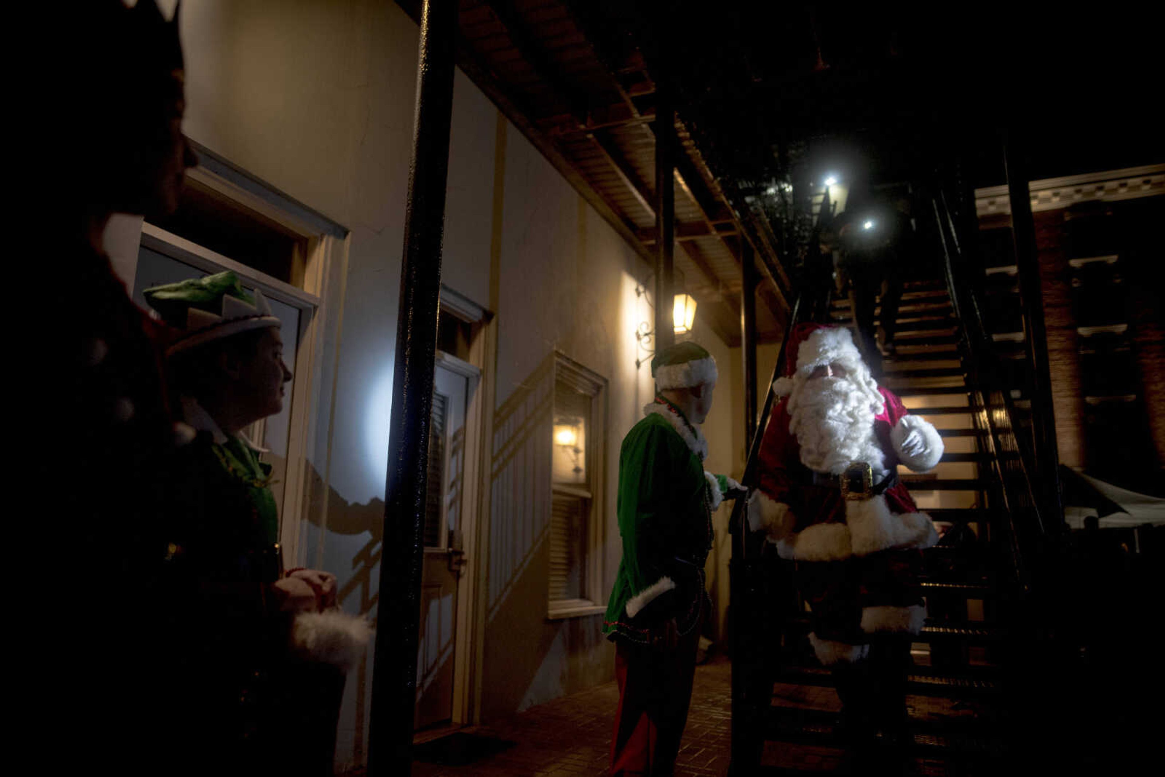 Santa Claus descends the staircase to light the tree during the inaugural Christmas tree lighting hosted by Old Town Cape Friday, Nov. 29, 2019, at the Vasterling Suites in Cape Girardeau.