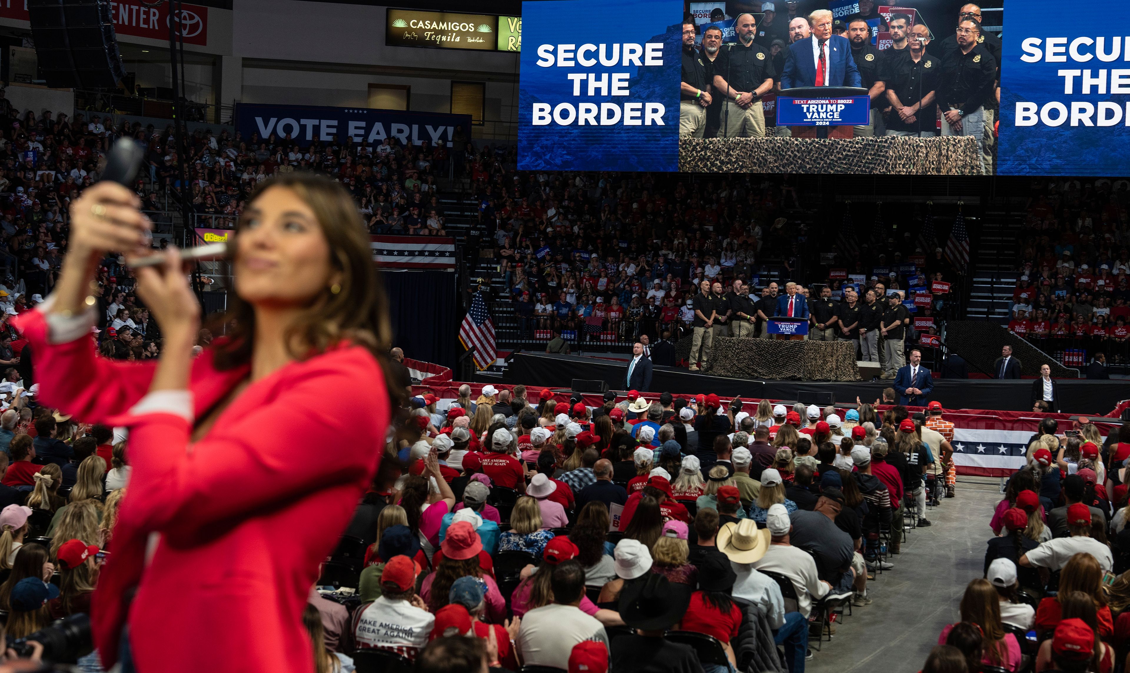 A TV reporter puts on make up while Republican presidential nominee former President Donald Trump delivers a speech during a campaign rally at the Findlay Toyota Arena, Sunday, Oct. 13, 2024, in Prescott Valley, Ariz. 