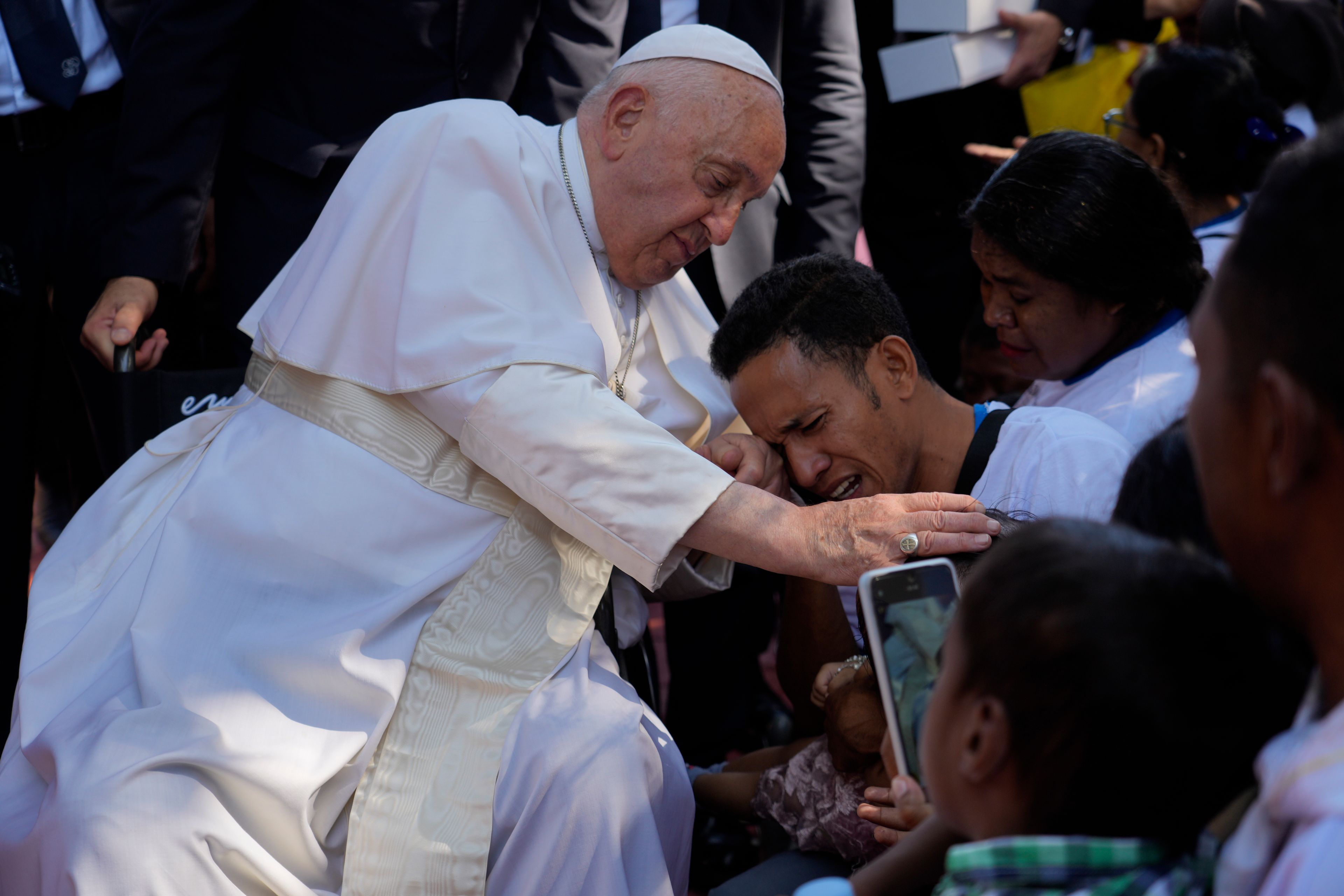 Pope Francis consoles a person during a visit at the 'Irmas ALMA' (Sisters of the Association of Lay Missionaries) School for Children with Disabilities in Dili, East Timor, Tuesday, Sept. 10, 2024. Pope Francis has indirectly acknowledged the abuse scandal in East Timor involving its Nobel Peace Prize-winning independence hero Bishop Carlos Filipe Ximenes Belo. (AP Photo/Gregorio Borgia)