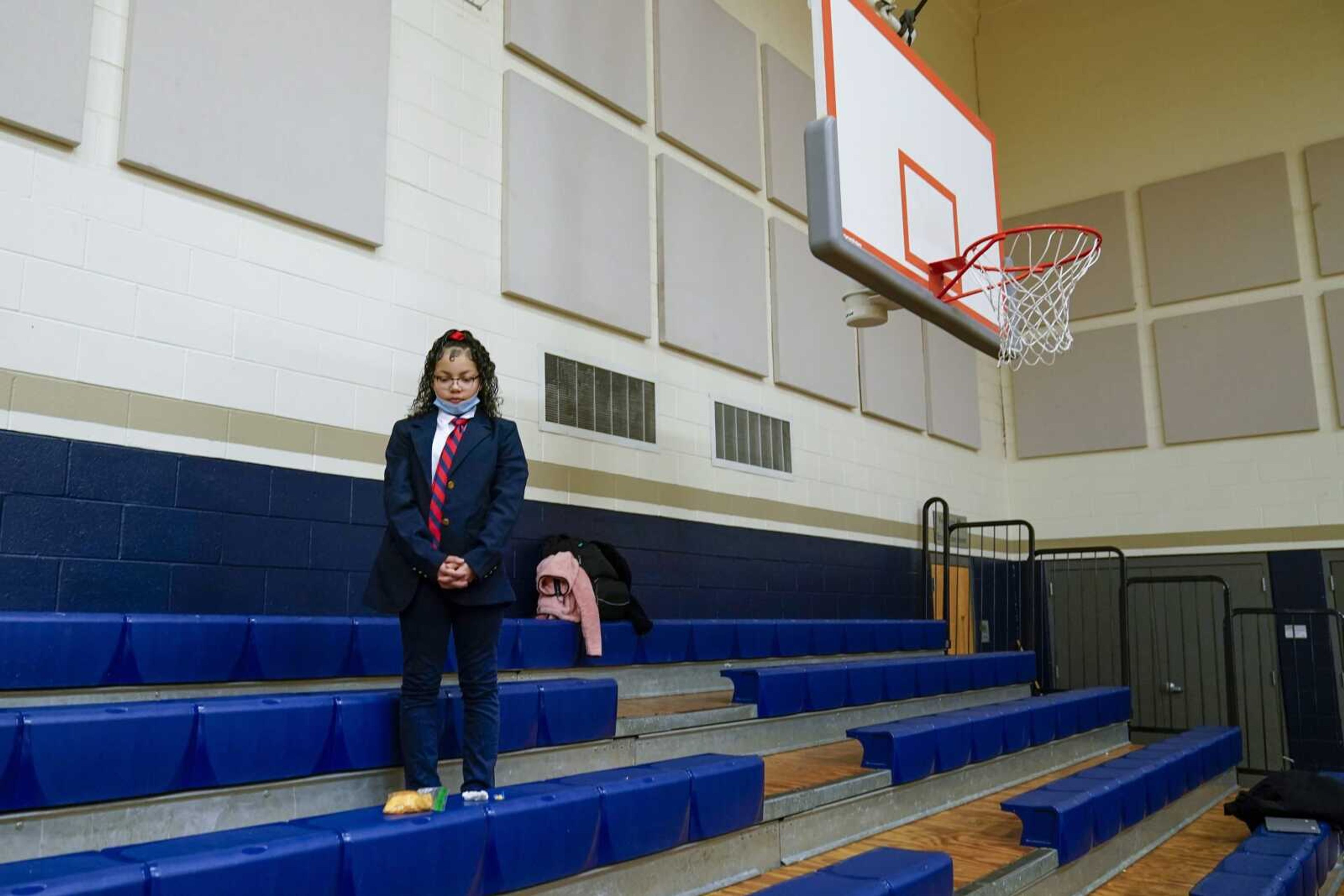 Annii Kinepoway pauses for a prayer in the bleachers at St. Marcus Lutheran School during the school's morning prayer Wednesday, Oct. 19, in Milwaukee.