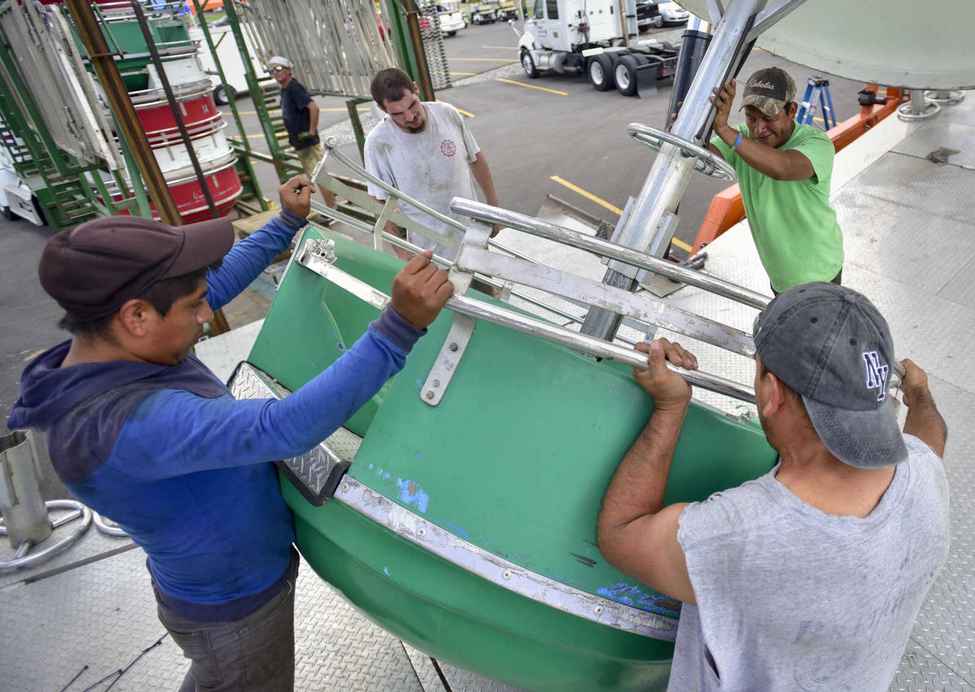 Carnival workers attach ferris wheel cars at the SEMO District Fairgrounds on Thursday, Sept. 6, 2018, in Cape Girardeau.