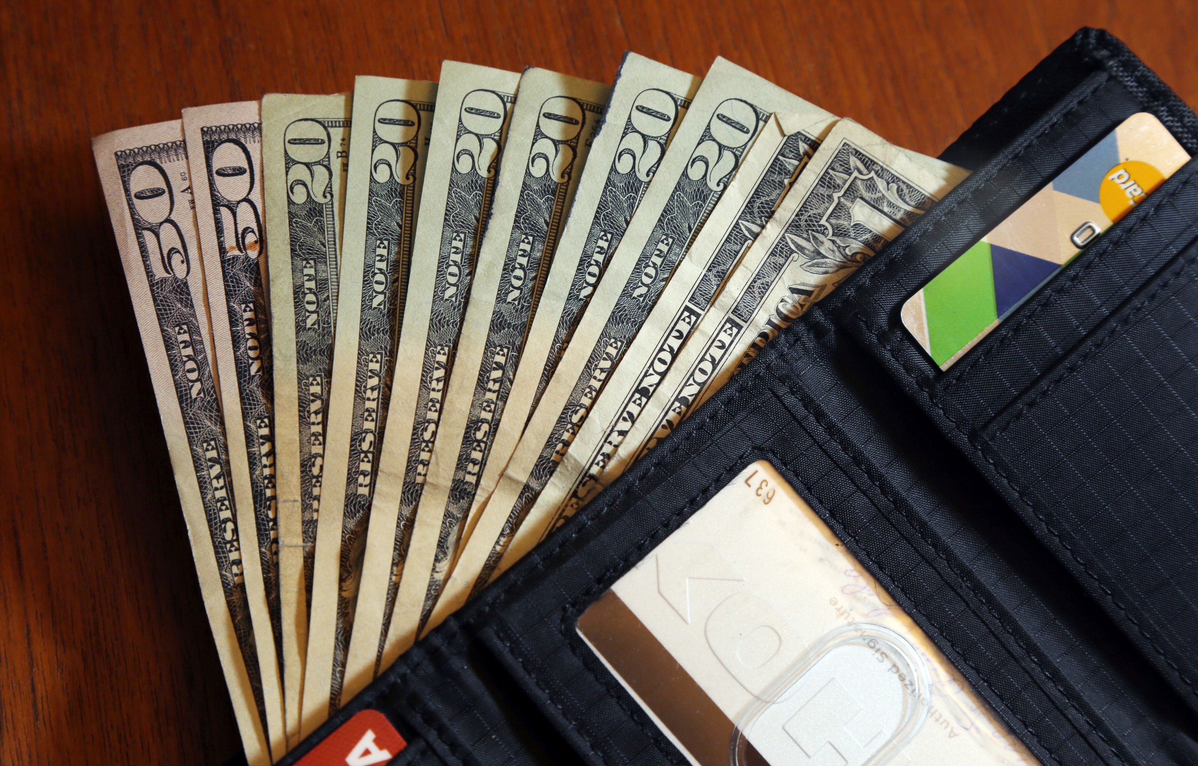 FILE - In this June 15, 2018, file photo, cash is fanned out from a wallet in North Andover, Mass. (AP Photo/Elise Amendola, File)