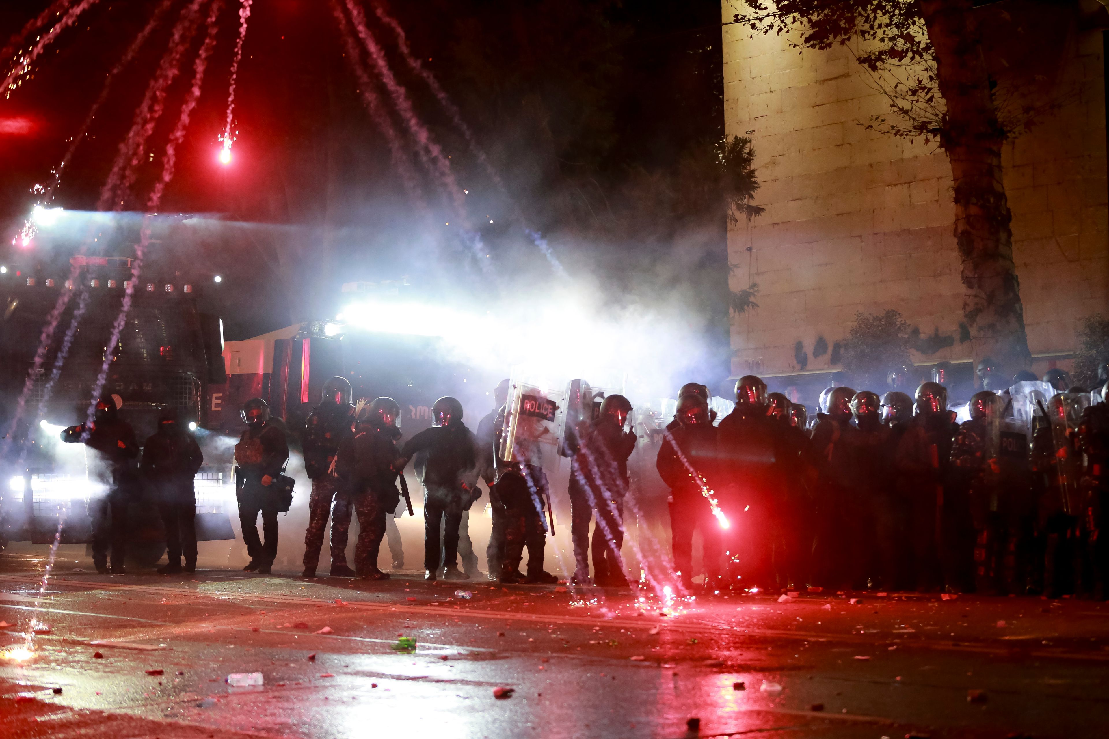 Demonstrators use firecrackers against police as police block a street to prevent protesters rallying against the government's decision to suspend negotiations on joining the European Union for four years, outside the parliament's building in Tbilisi, Georgia, early Saturday, Nov. 30, 2024. (AP Photo/Zurab Tsertsvadze)