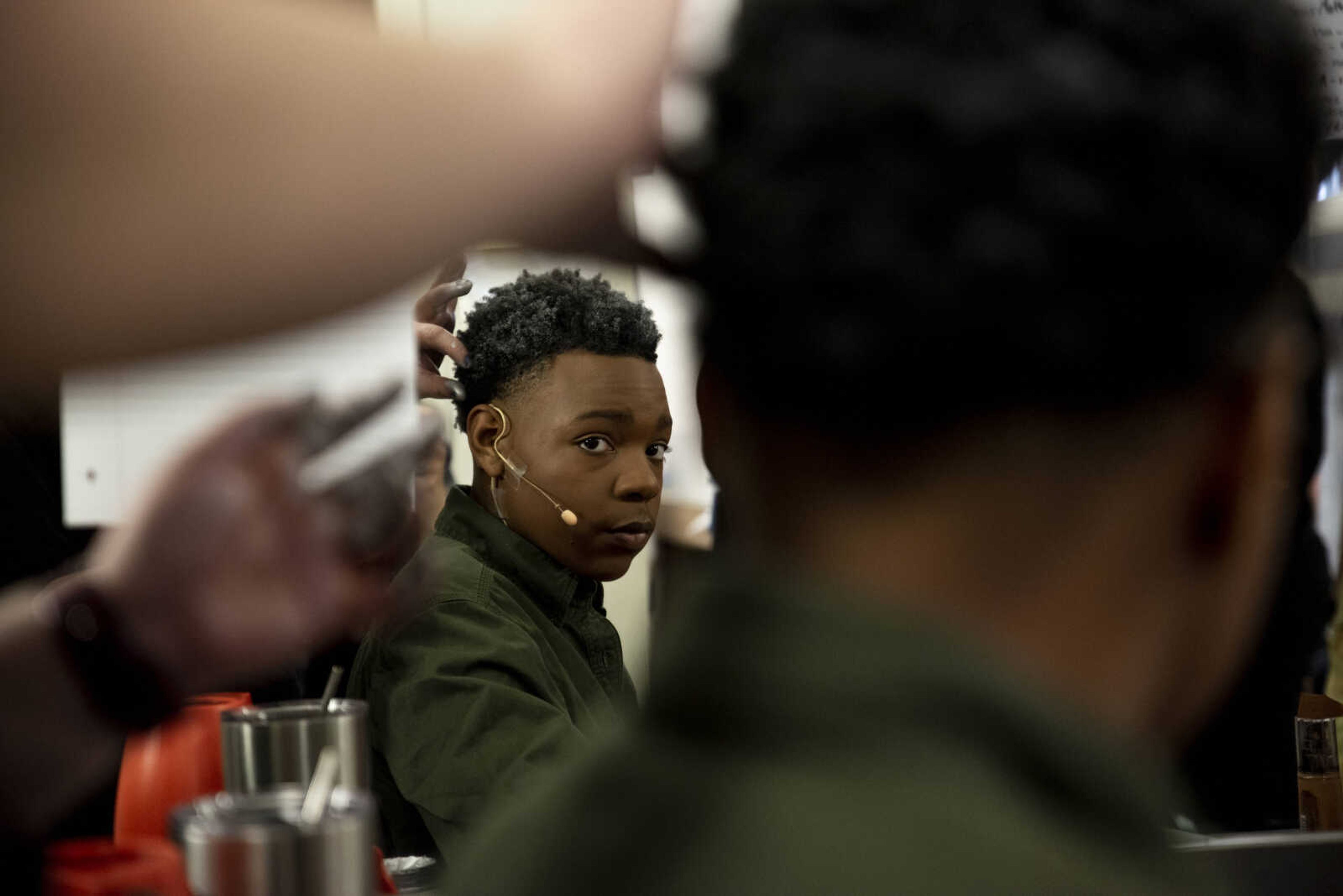 Isaah Williams looks at his reflection as his character makeup and hair for the role of Sam Carmichael is finished up by Kali Whitworth during the media night of Cape Central High School's spring musical production of "Mamma Mia!" Wednesday, April 10, 2019, in Cape Girardeau.