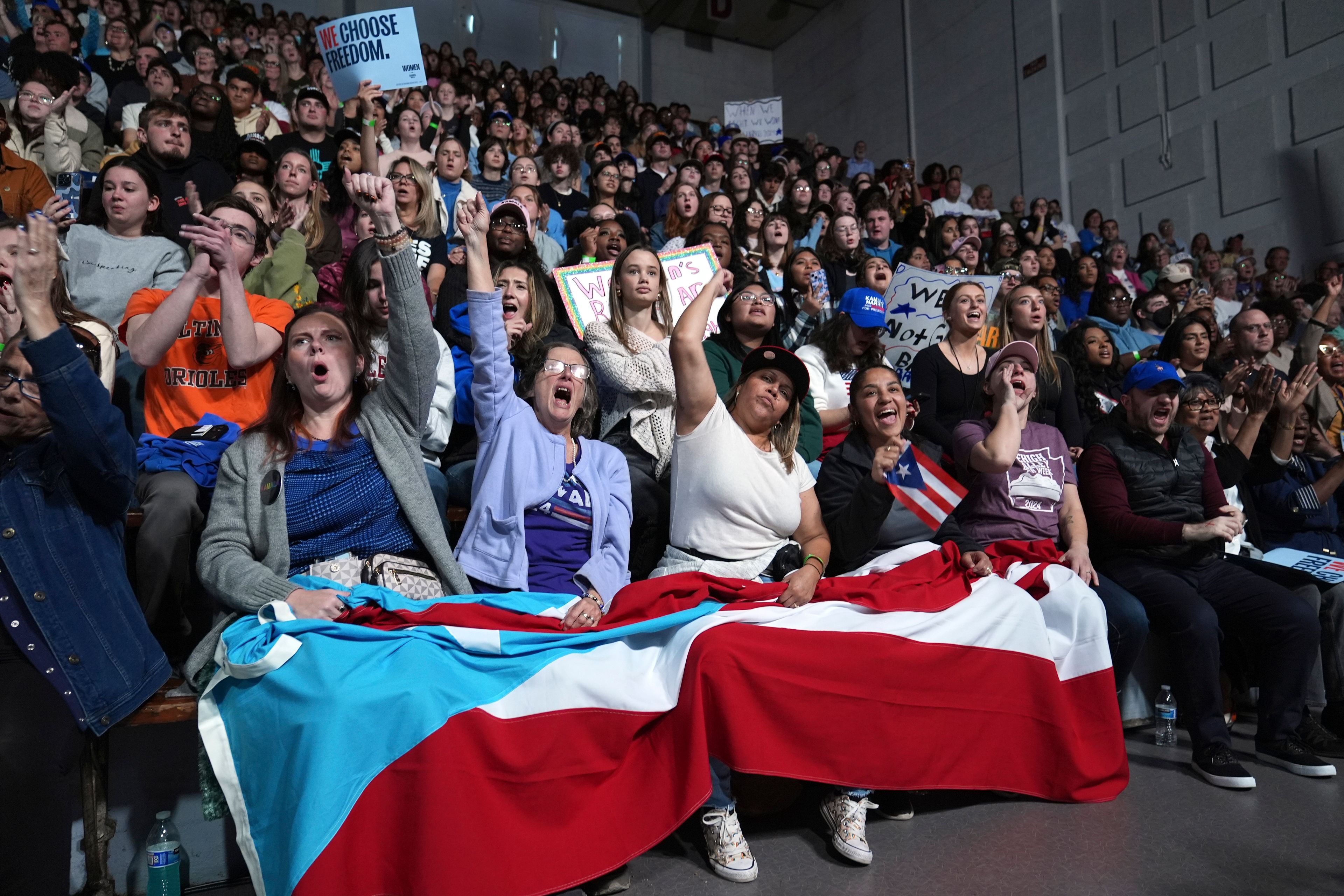 Attendees holding the flag of Puerto Rico cheer as Allentown, Pa. Mayor Matt Tuerk speaks during a campaign rally for Democratic presidential nominee Vice President Kamala Harris in Memorial Hall at Muhlenberg College in Allentown, Pa., Monday, Nov. 4, 2024. (AP Photo/Susan Walsh)