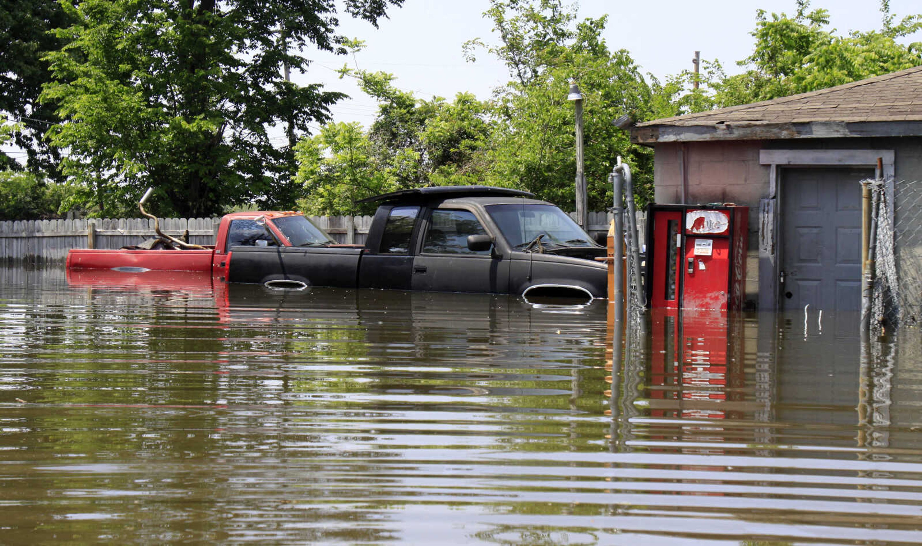 Two pickup trucks are seen surrounded by floodwater outside a garage Sunday, May 8, 2011, in Memphis, Tenn. More Memphis residents were being told Sunday to flee their homes for higher ground as the mighty Mississippi River edged toward the city, threatening to bring more flooding to parts of an area already soaked. (AP Photo/Jeff Roberson)