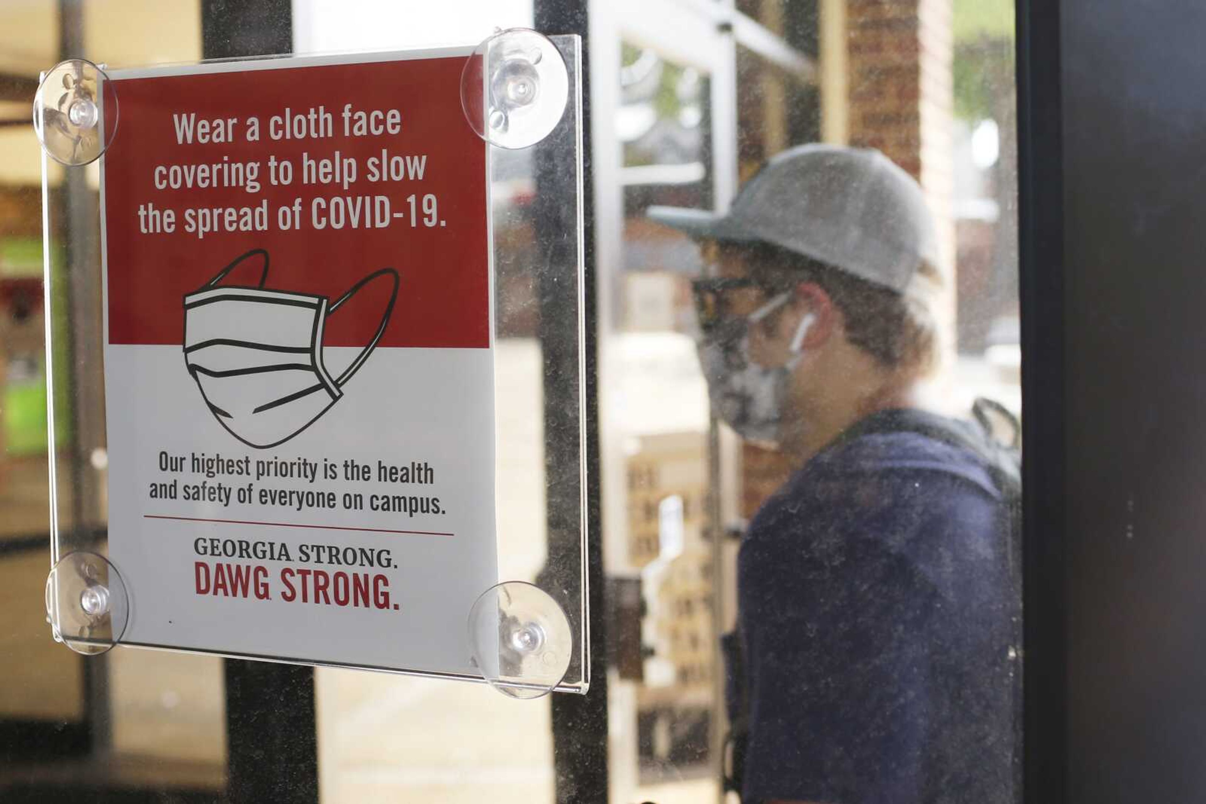 FILE - In this Aug. 20, 2020, file photo, a student, wearing a face mask, enters the school book store at the University of Georgia in Athens, Ga. The number of Americans newly diagnosed with the coronavirus is falling Â‚Ã„Ã® a development experts credit at least partly to increased wearing of masks Â‚Ã„Ã® even as the outbreak continues to claim nearly 1,000 lives in the U.S. each day. (Joshua L. Jones/Athens Banner-Herald via AP)