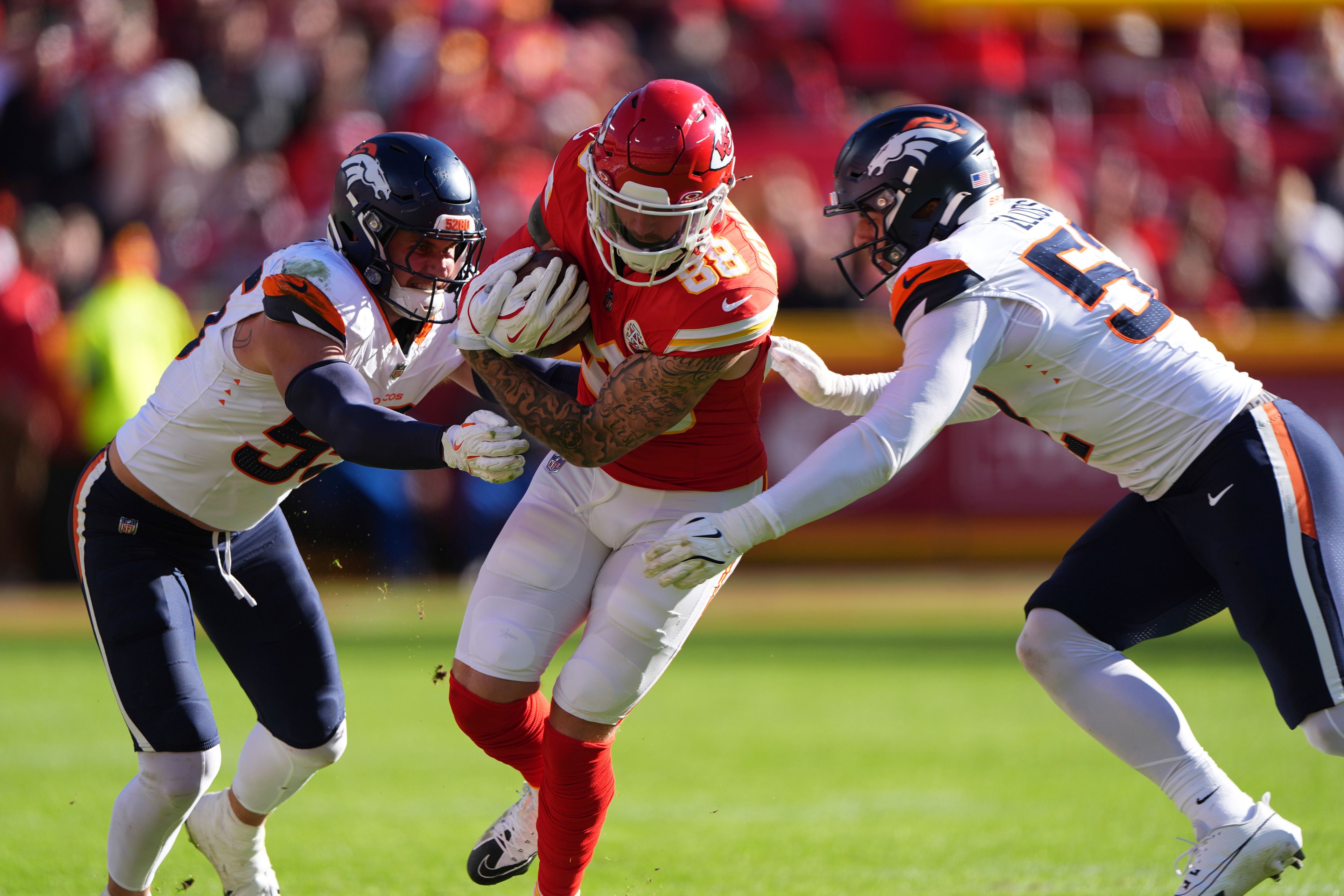 Kansas City Chiefs tight end Peyton Hendershot (88) runs with the ball as Denver Broncos inside linebacker Cody Barton and outside linebacker Jonah Elliss, right, defend during the second half of an NFL football game Sunday, Nov. 10, 2024, in Kansas City, Mo. (AP Photo/Charlie Riedel)