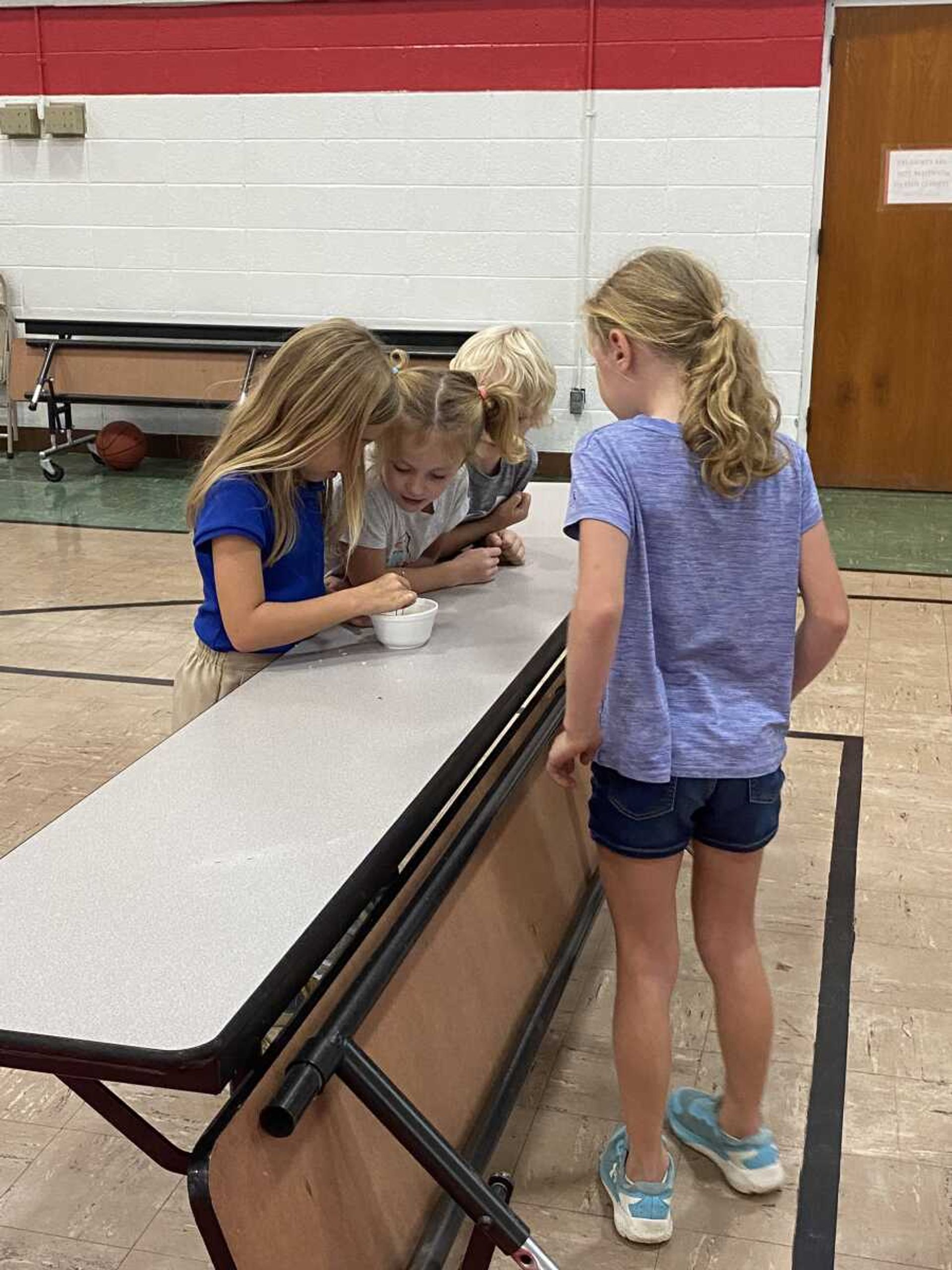 Amelia Kyle stirs and stirs to find a black kernal of rice in the bowl.  Teagan King, Victor Woods, & Aubrey Graviett, the other 3 participants from St. Gabriel's house in that game look on.