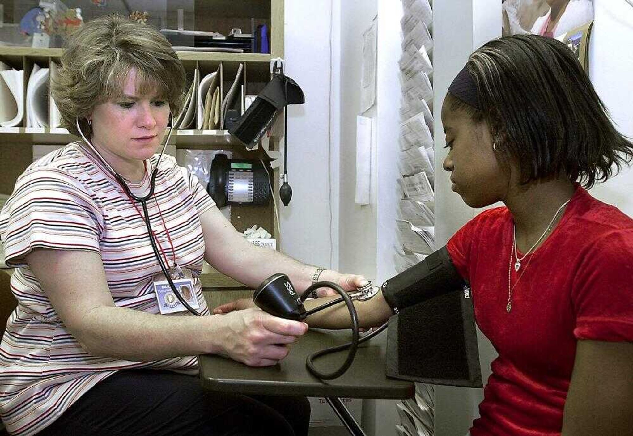 Deidra King (R), 16, of Cape Girardeau had her blood pressure checked by Registered Nurse Nina Marshall as part of sports physical during a visit to the Cape Girardeau County Public Health Center Monday, April 7, 2003.   (DON FRAZIER * dfrazier@semissourian.com)