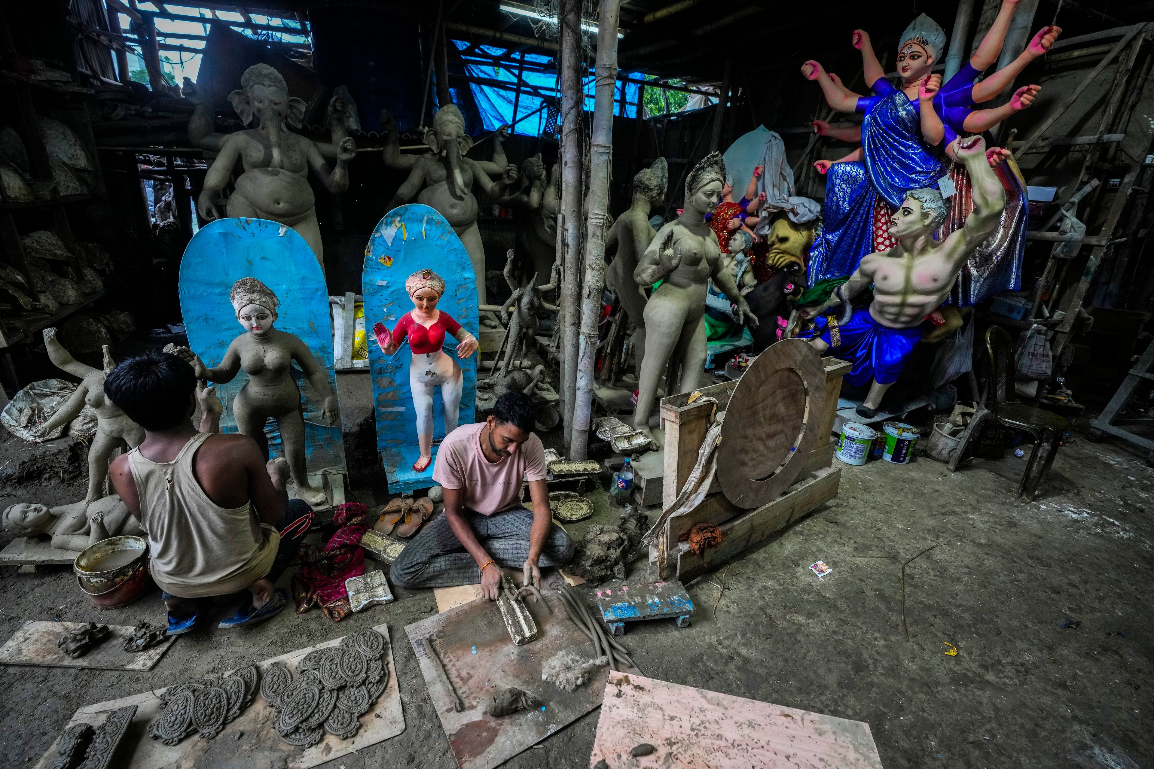 Artisans prepare mud idols of the Hindu goddess Durga and other deities at a workshop during the Durga Puja festival in Guwahati, India, Saturday, Oct. 5, 2024. (AP Photo/Anupam Nath)