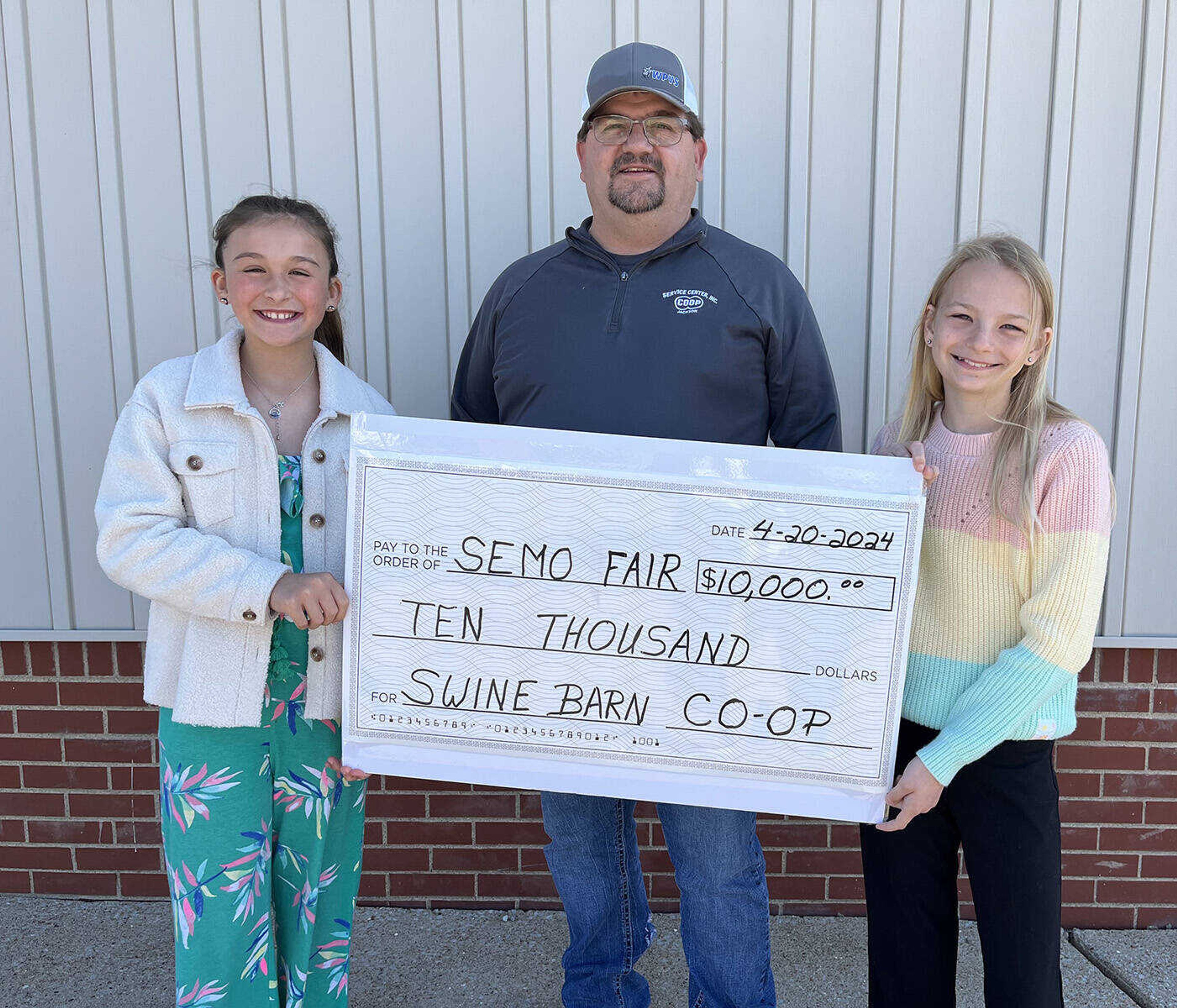 4-H members Parker Pylate (left) and Eve Nothdurft (right) receiving a $10,000.00 donation from David Coomer, Jackson CO-OP Manager for new swine barn at SEMO District Fair