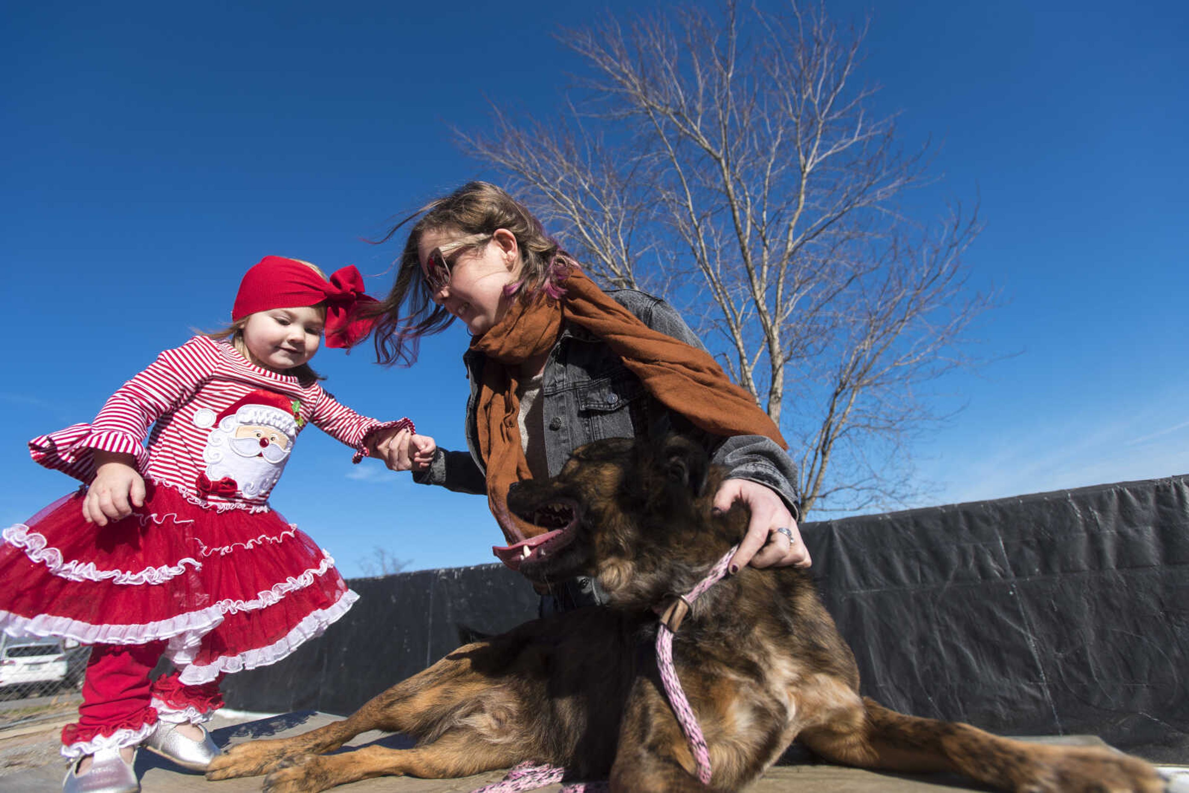 Haleigh Givens, center, and her niece Grace Brumbaugh, 1, play with Haleigh's surprise adopted dog, Radley, at the 40th anniversary of the Humane Society of Southeast Missouri Saturday, Dec. 16 , 2017 in Cape Girardeau.