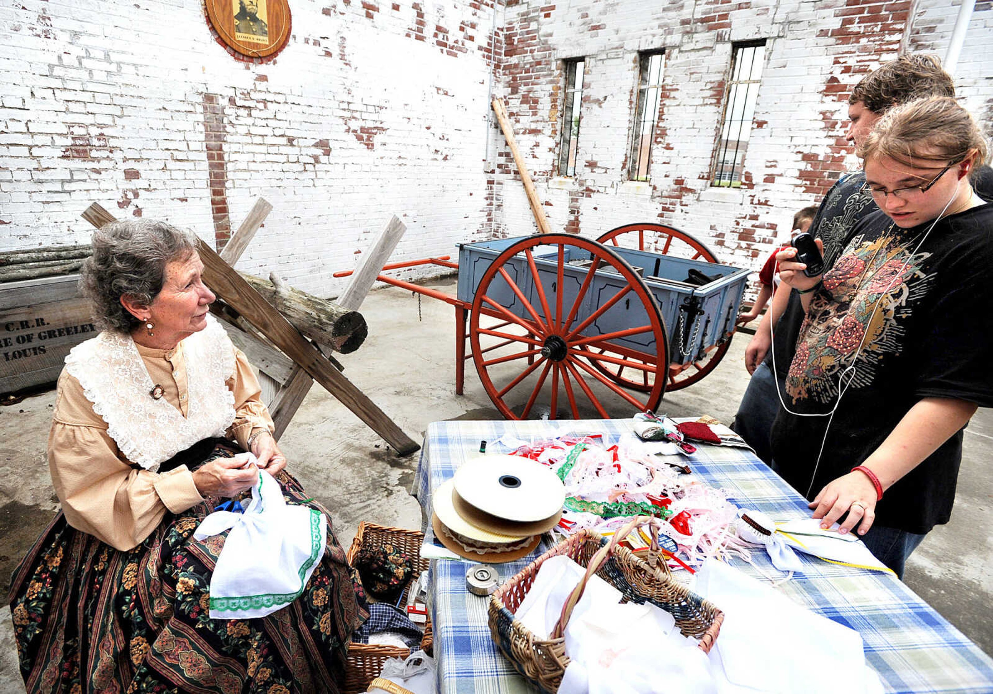 LAURA SIMON ~ lsimon@semissoruian.com
Pat Hagler, left, tells Erica Morland and Jody Maloney about the church dolls she is creating Monday, Sept. 3, 2012 during Labor Day at Fort D in Cape Girardeau. "Grandmothers would make them for children so they would be quiet in church," Hagler said.