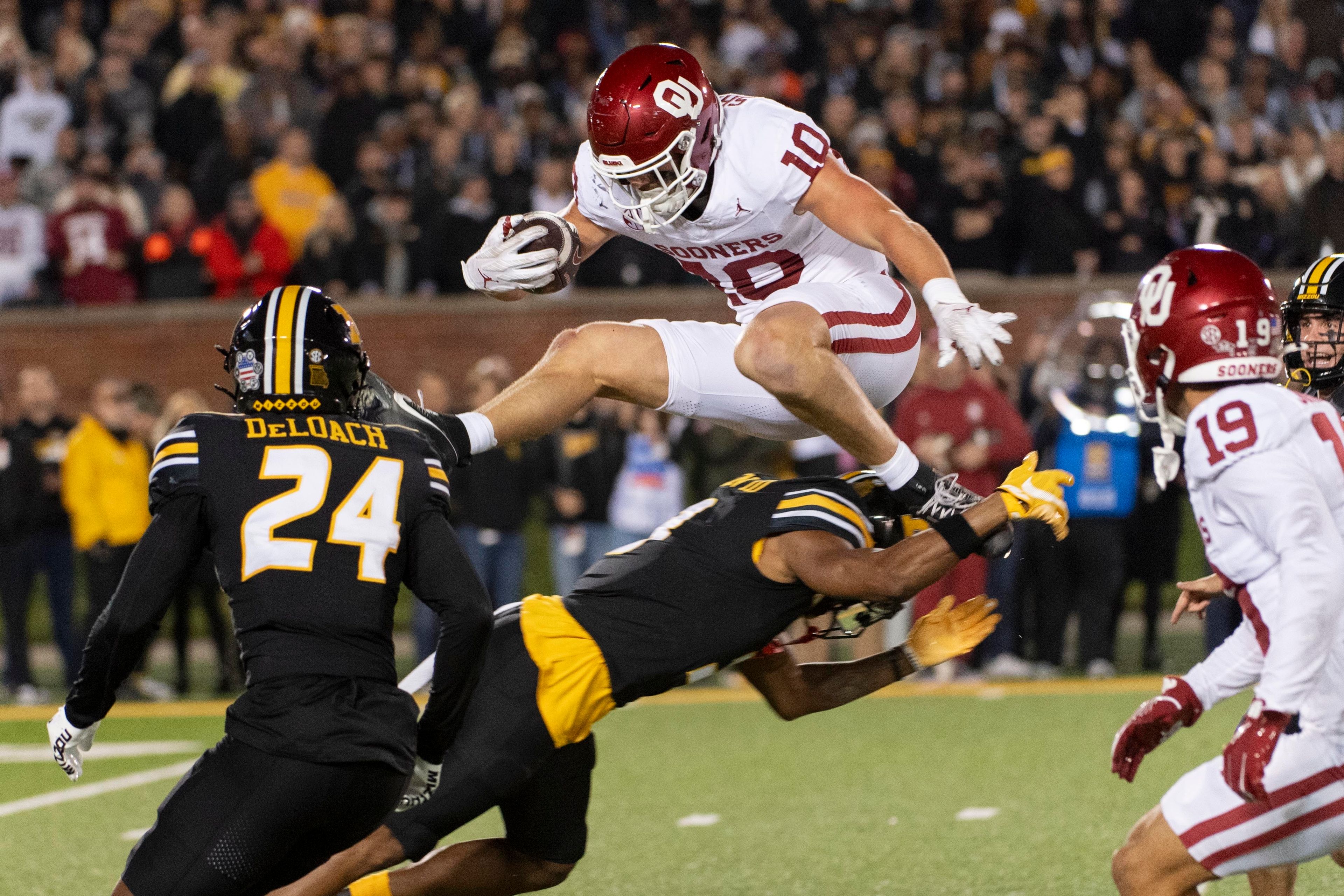 Oklahoma tight end Bauer Sharp (10) jumps over Missouri's Luther Burden III, bottom during a fake punt in the first half of an NCAA college football game Saturday, Nov. 9, 2024, in Columbia, Mo. (AP Photo/L.G. Patterson)