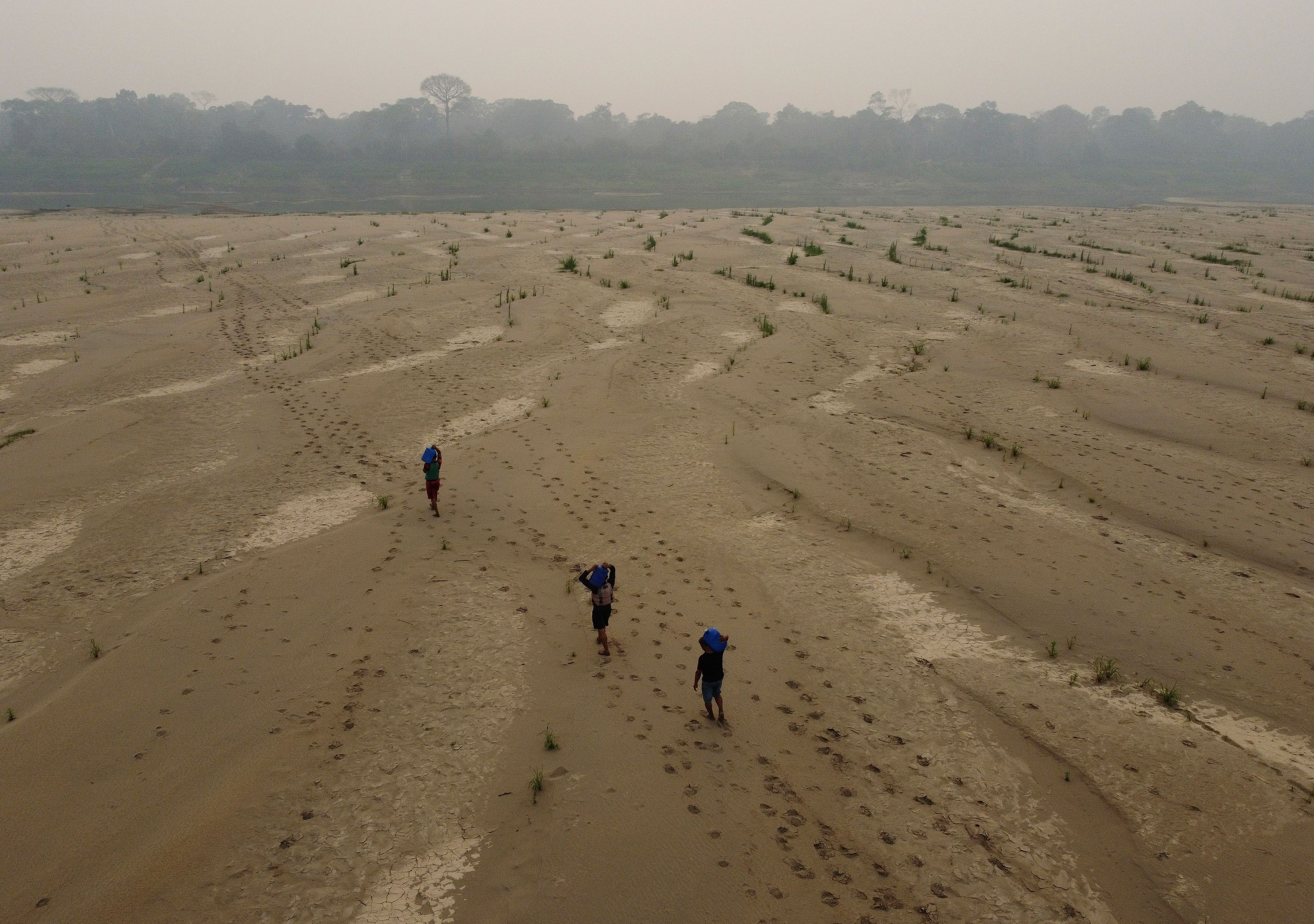 FILE - Residents transport drinking water from Humaita to the Paraizinho community, along the dry Madeira River, a tributary of the Amazon River, amid a drought, in Amazonas state, Brazil, Sunday, Sept. 8, 2024. (AP Photo/Edmar Barros)