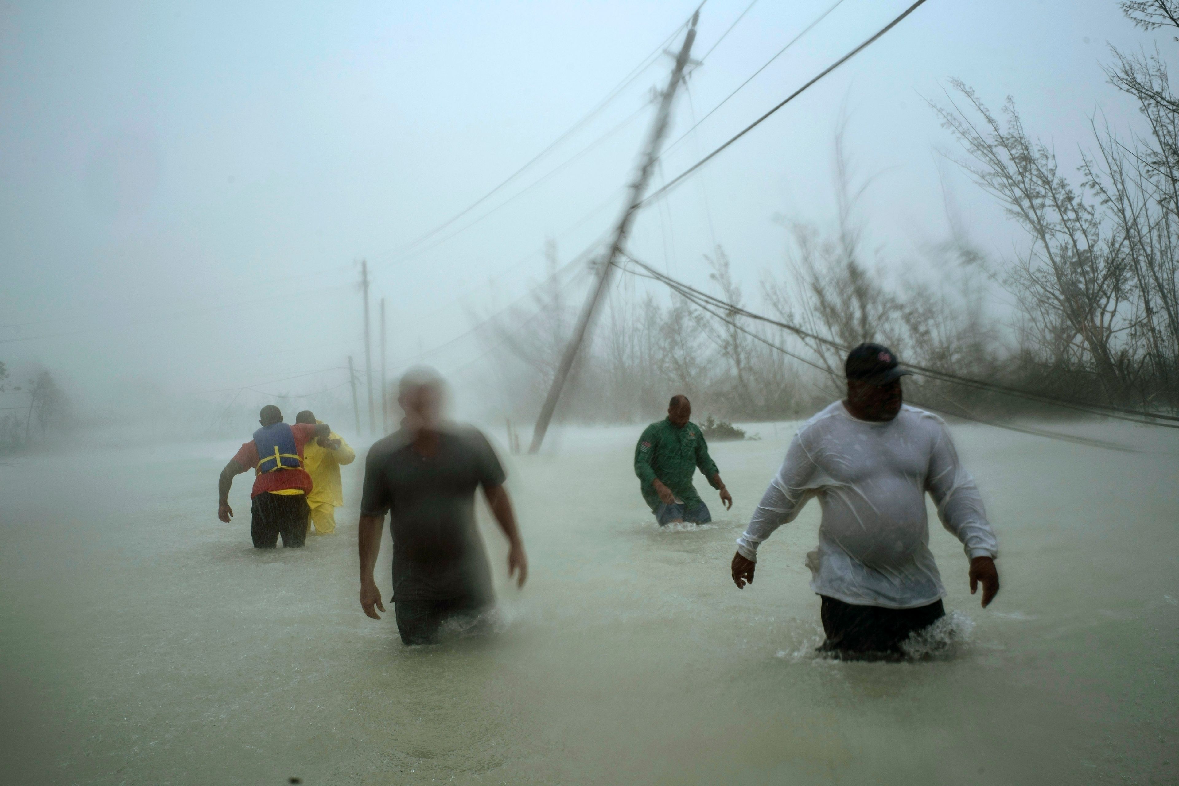 FILE - Volunteers wade through a flooded road in the aftermath of Hurricane Dorian to rescue families near the Causarina bridge in Freeport, Grand Bahama, Bahamas, on Sept. 3, 2019. (AP Photo/Ramon Espinosa)