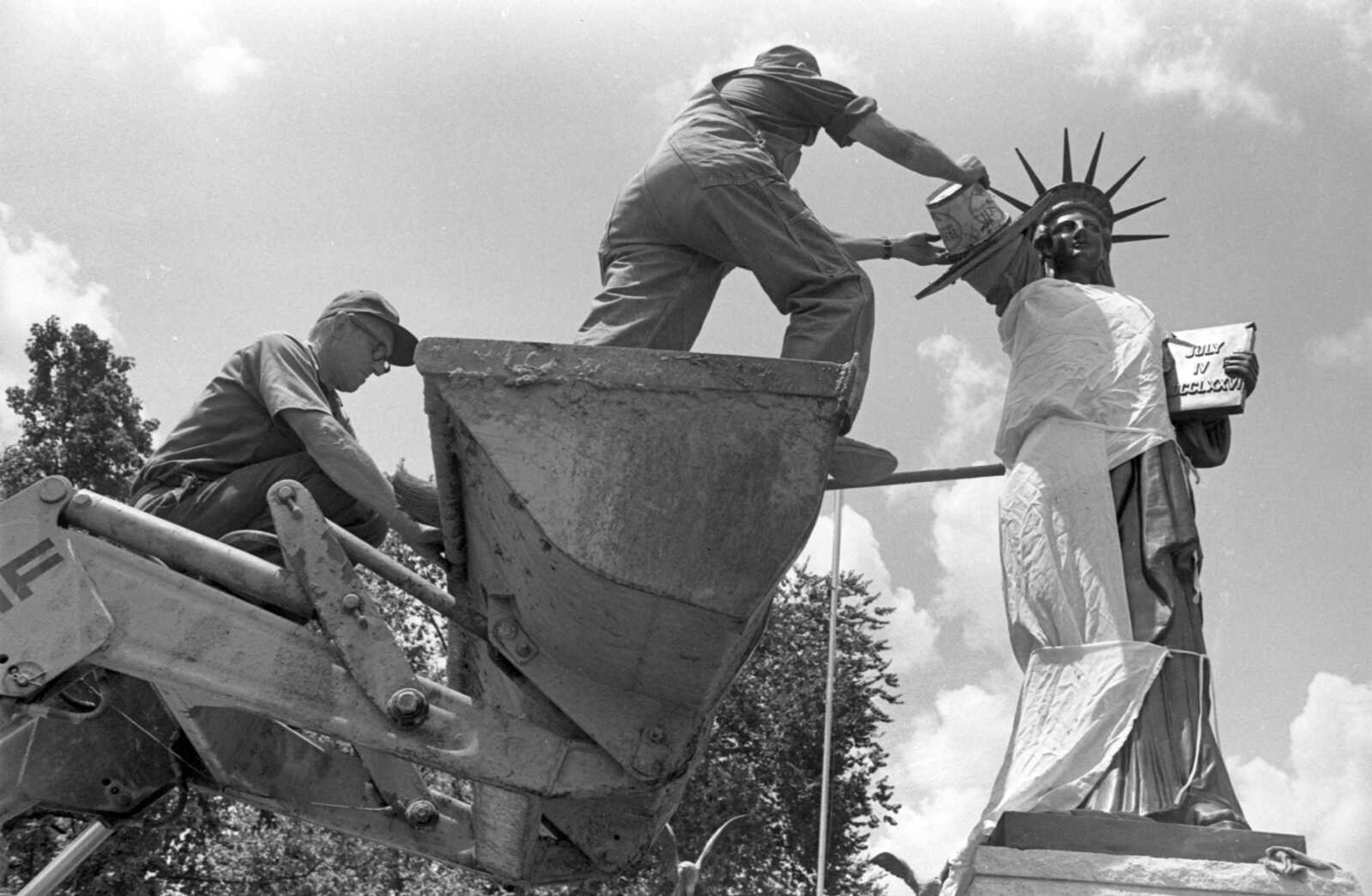 Pulbished Friday, July 2, 1976
The Statue of Liberty has been returned to her place of honor, guarding Freedom Corner after vandals threw her in a ditch in May. Martin Heider, Jackson, and Linus Quade, Burfordville, city workers, prepare her so that the arm can be remounted. (Missourian archive photo by Gordon L. McBride)