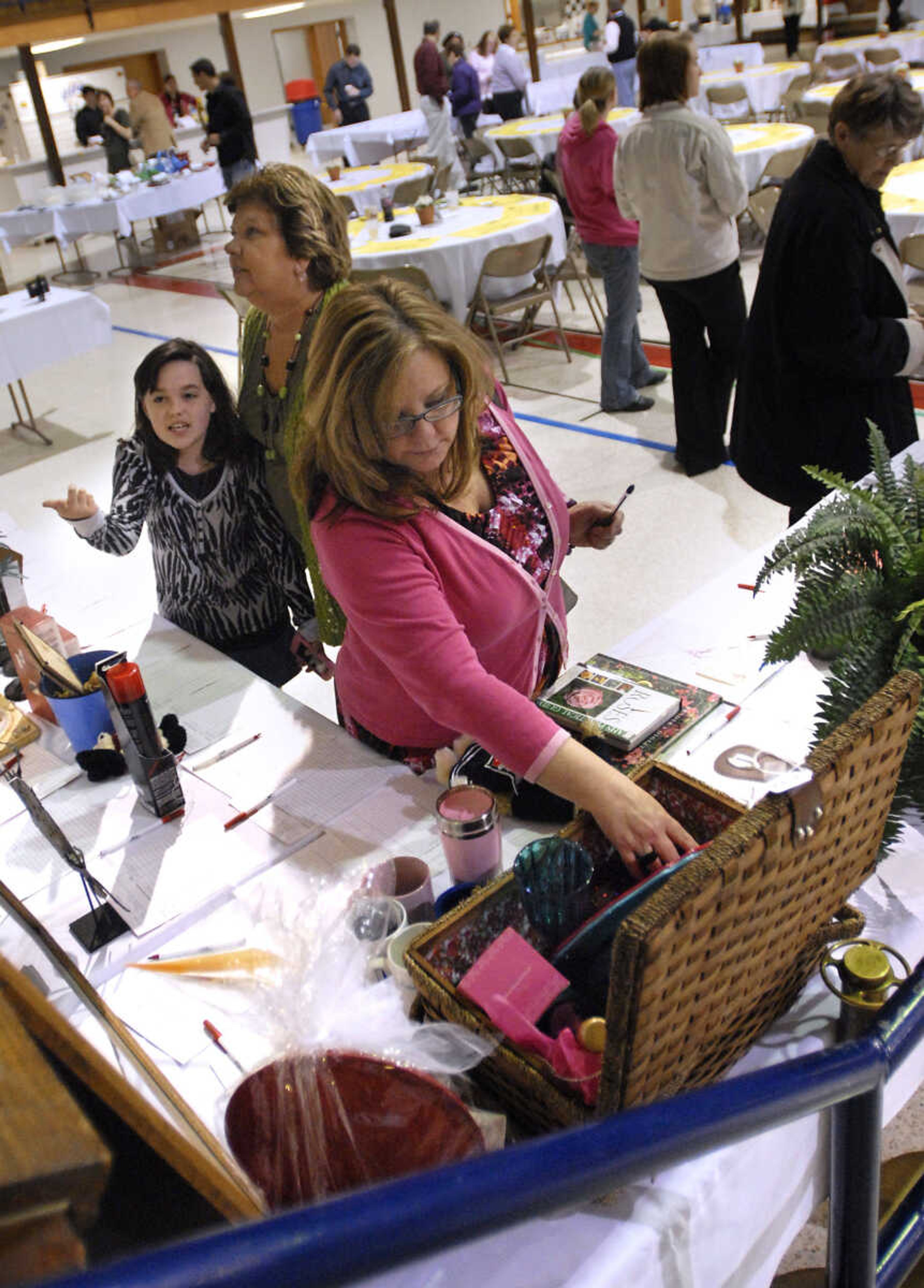 KRISTIN EBERTS ~ keberts@semissourian.com

Abbi Nix, grandmother Carolyn Walton and Sherry Jennings, from left, check out the items in the silent auction during the Humane Society of Southeast Missouri's 30th annual Dinner and Auction titled "Tales of Tails" on March 26, 2011, at the A.C. Brase Arena in Cape Girardeau. The event included dinner, awards, raffles and silent and oral auctions with proceeds benefitting the Humane Society.