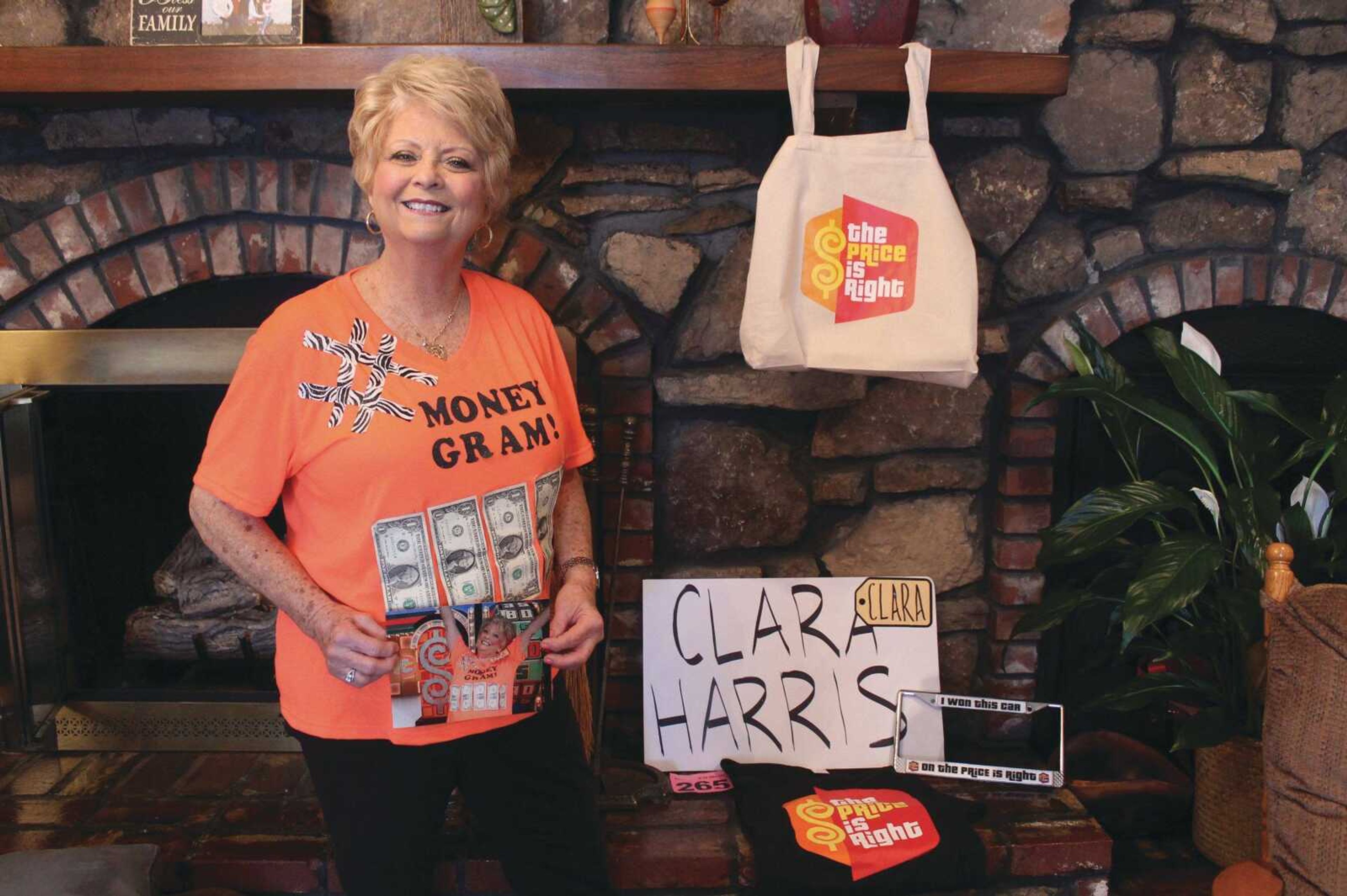 Clara Harris stands next to a lot of the memorabilia she received at "The Price Is Right" game show in Los Angeles. One of the items included a license plate frame that says, "I won this car on The Price Is Right." She will put that on her Volkswagen Beetle when it arrives.