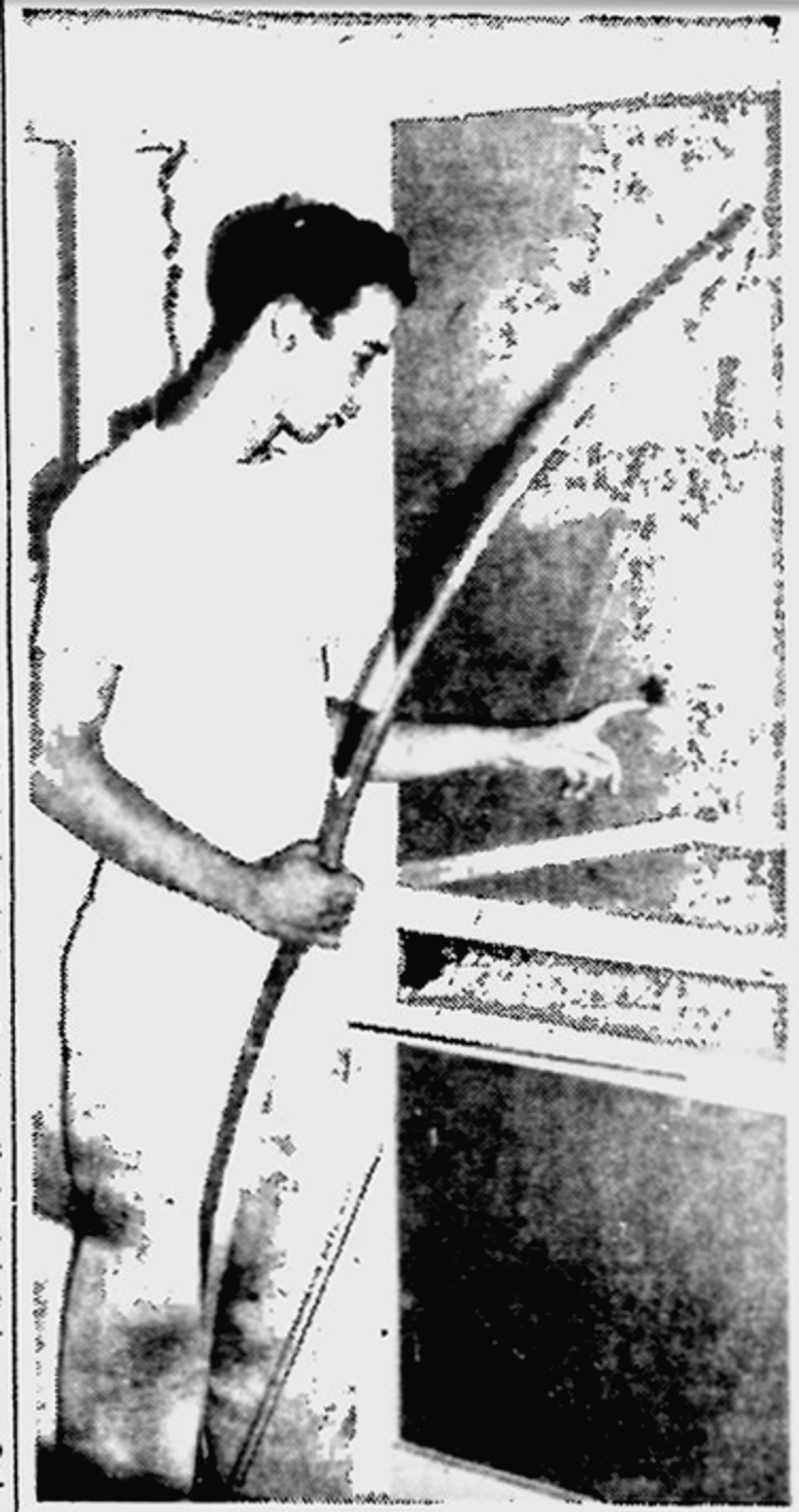 Bill Watkins, 21-year-old post office worker, examines the hole made in the screen door of his second-story porch, when he shot an arrow at a prowler early Friday morning, Aug. 12, 1949. He's holding the bow he used in his hand. 