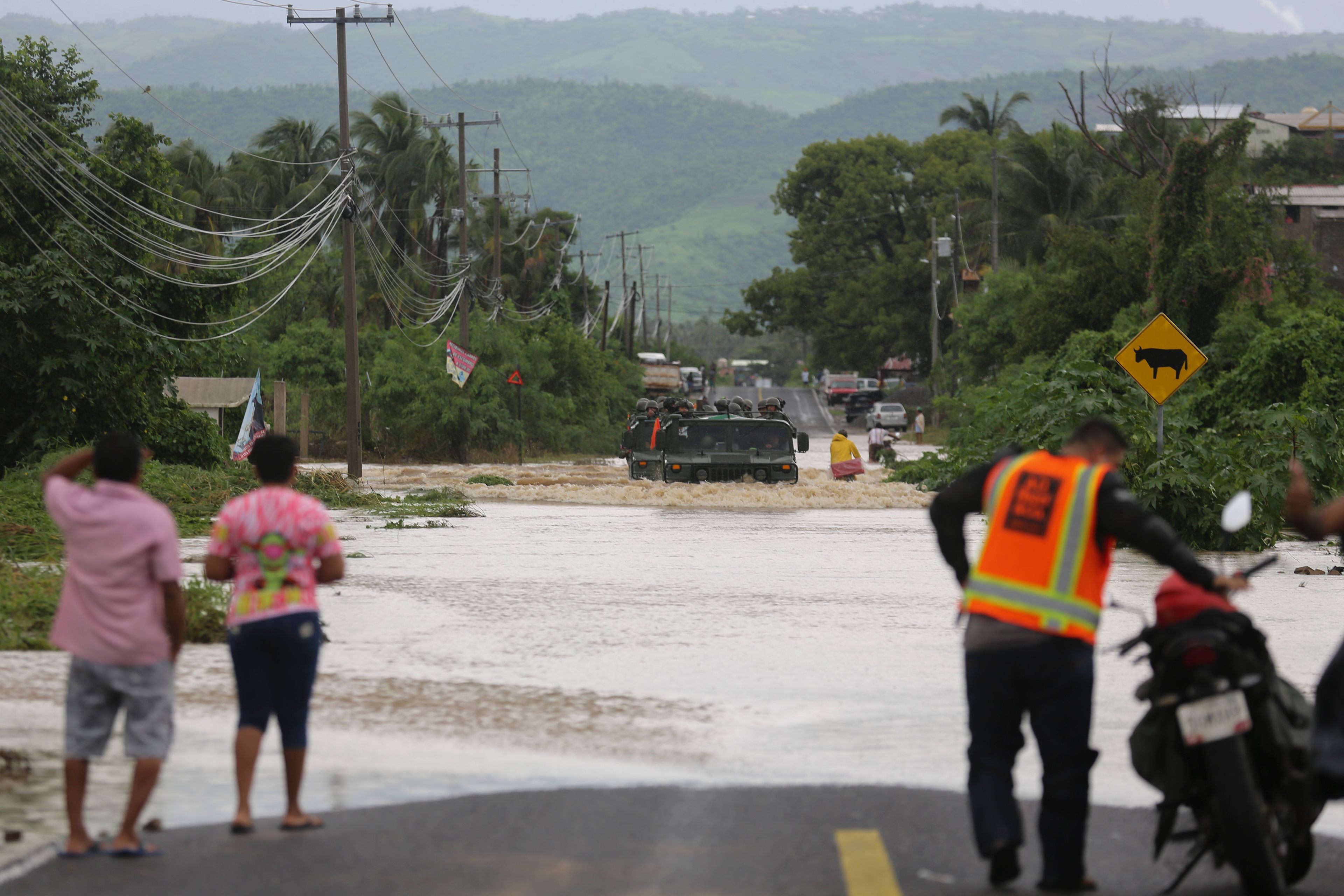 An army vehicle negotiates a street flooded by the passing of Hurricane John, in Acapulco, Mexico, Friday, Sept. 27, 2024. (AP Photo/Bernardino Hernandez)