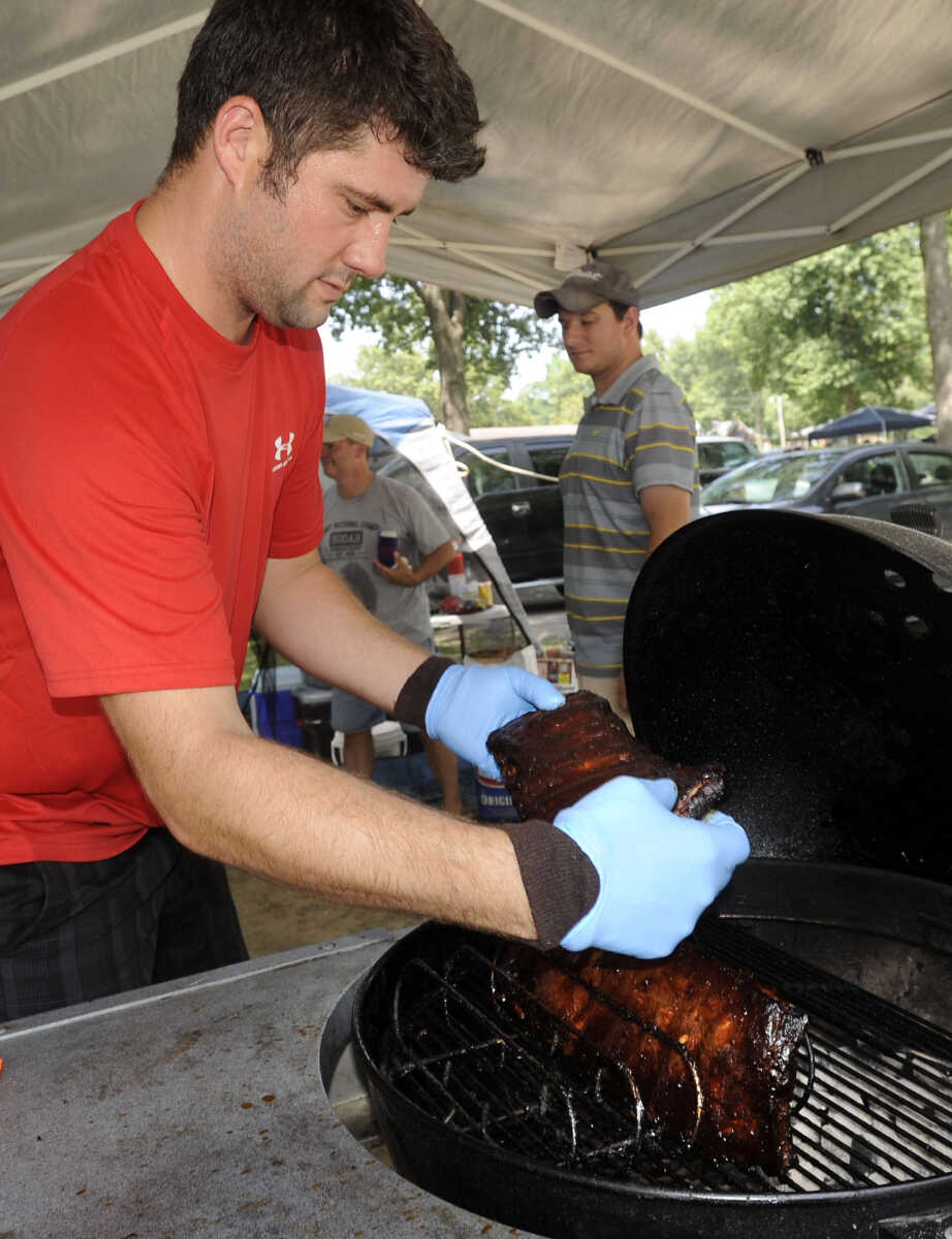 David Wallis with San Dangaro Porkers prepares ribs for judging Saturday, Aug. 23, 2014 at the Cape BBQ Fest in Arena Park.