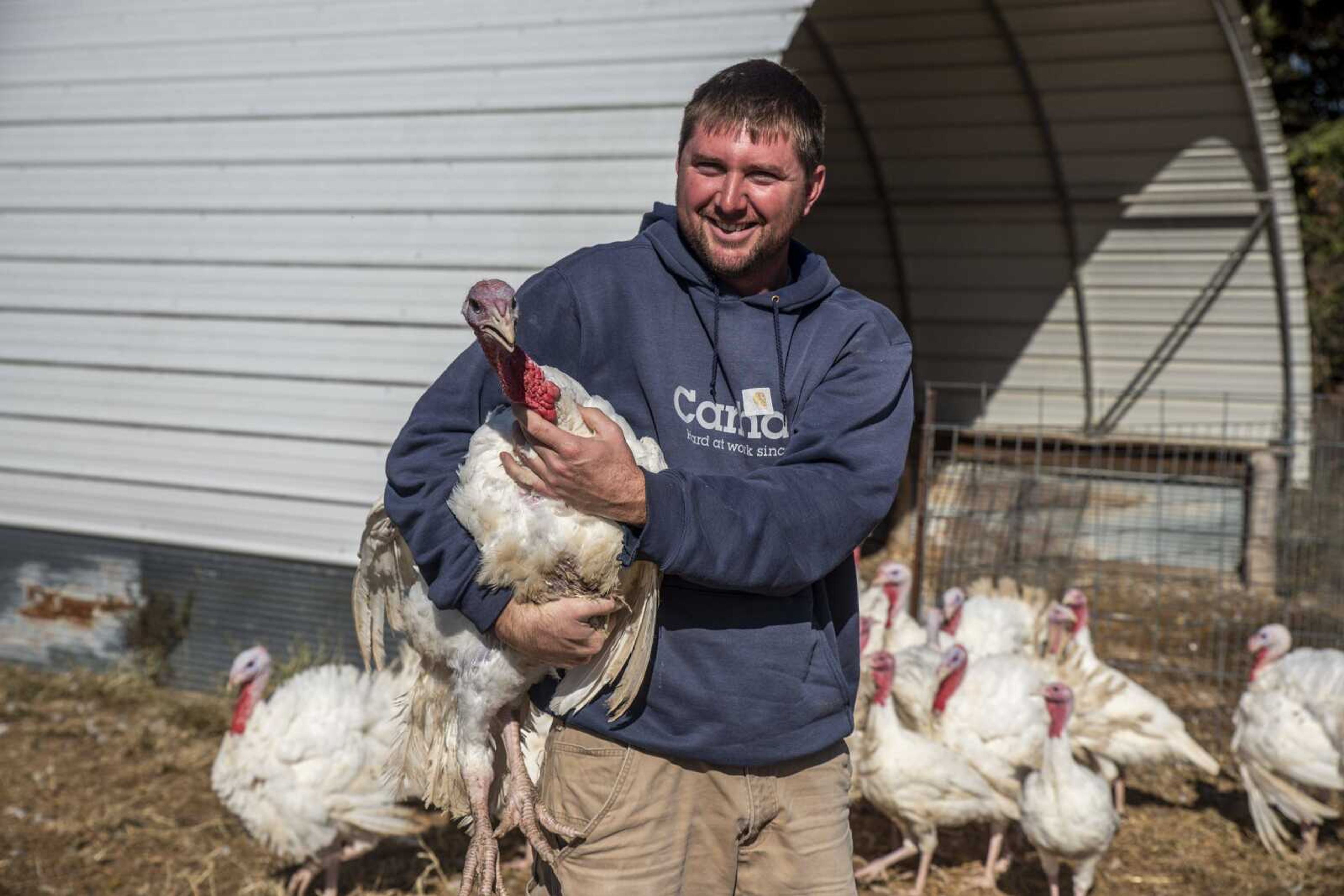 Colby Jones holds a turkey at Farrar Out Farm Oct. 23 in rural Perry County.