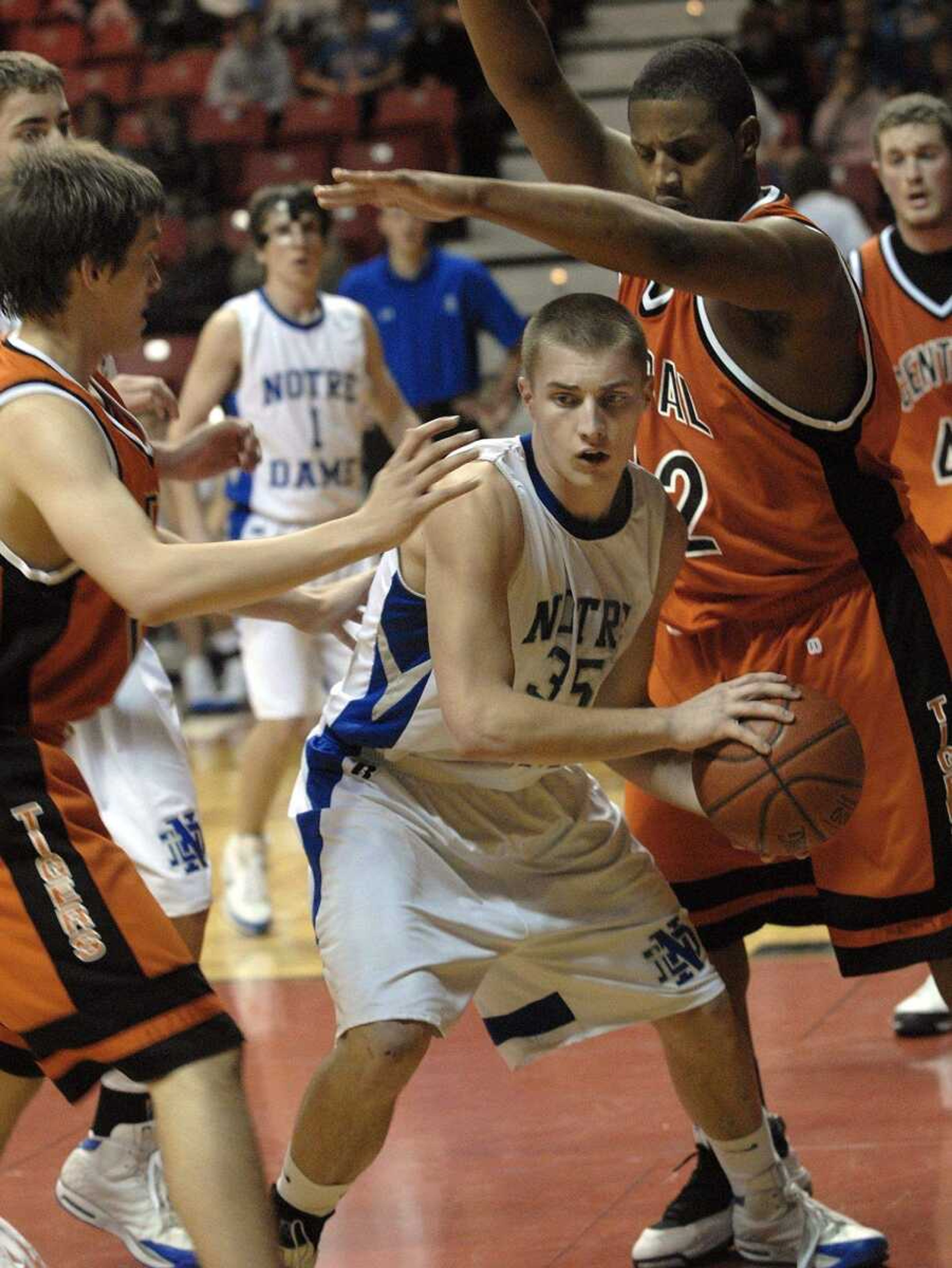 FRED LYNCH ~ flynch@semissourian.com
Notre Dame's Joseph Tolbert looks to pass as Central's Blake Ozbun, left, and Rick Russell defend in the third quarter Monday at the Show Me Center.