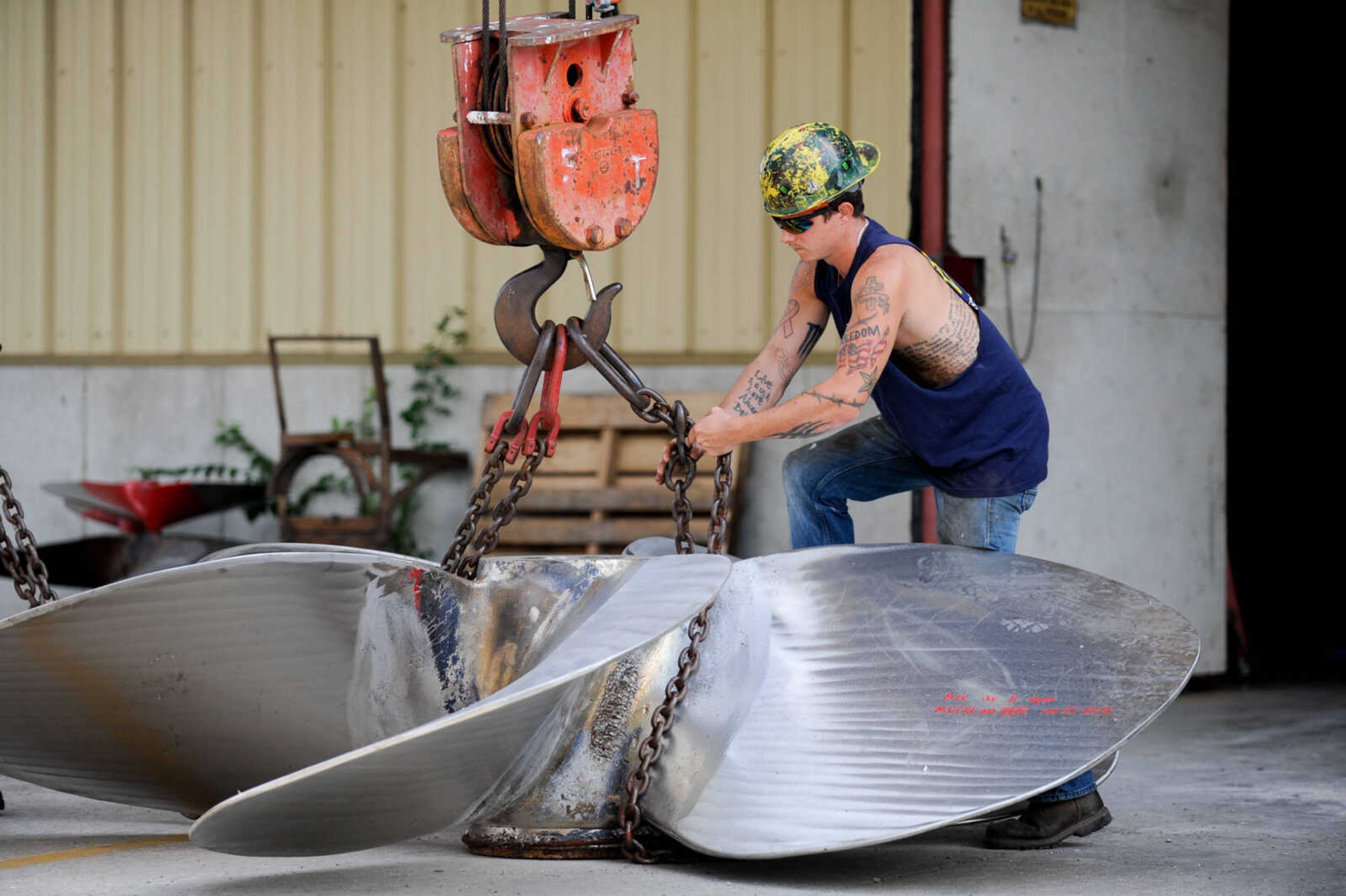 GLENN LANDBERG ~ glandberg@semissourian.com

Keegan Hale hooks chains around a propeller to be moved at Missouri Dry Dock and Repair Co. in Cape Girardeau Wednesday, July 28, 2016.