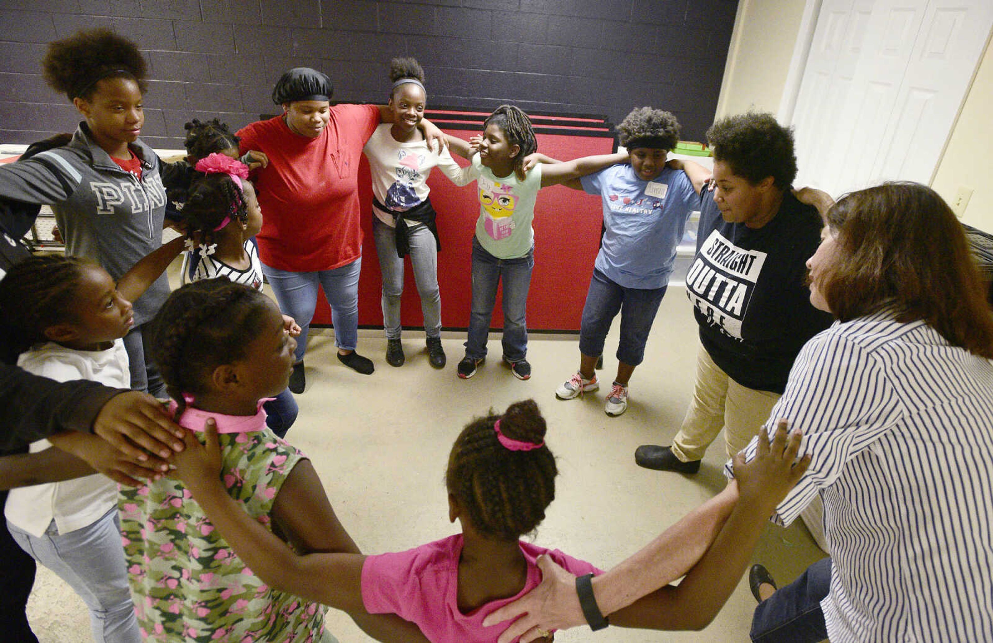 Girls and volunteers dance in a circle on Monday, Aug. 14, 2017, during the Salvation Army's after school program at The Bridge Outreach Center in Cape Girardeau.