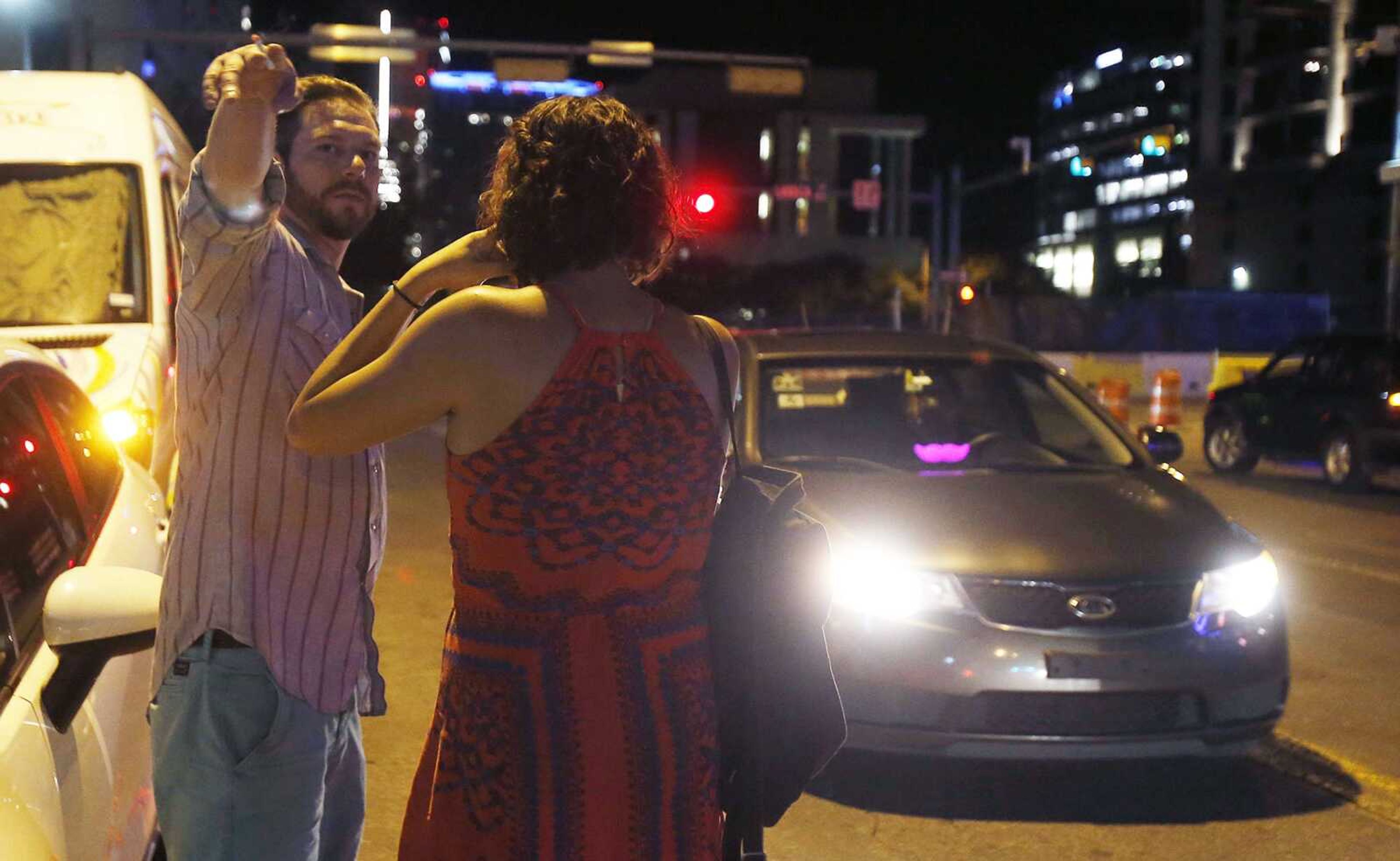 Ryan Murphy and Lindsey Jones look for the Uber they requested on May 6 on 4th Street in Austin, Texas. Uber and Lyft suspended service in Austin on May 9.